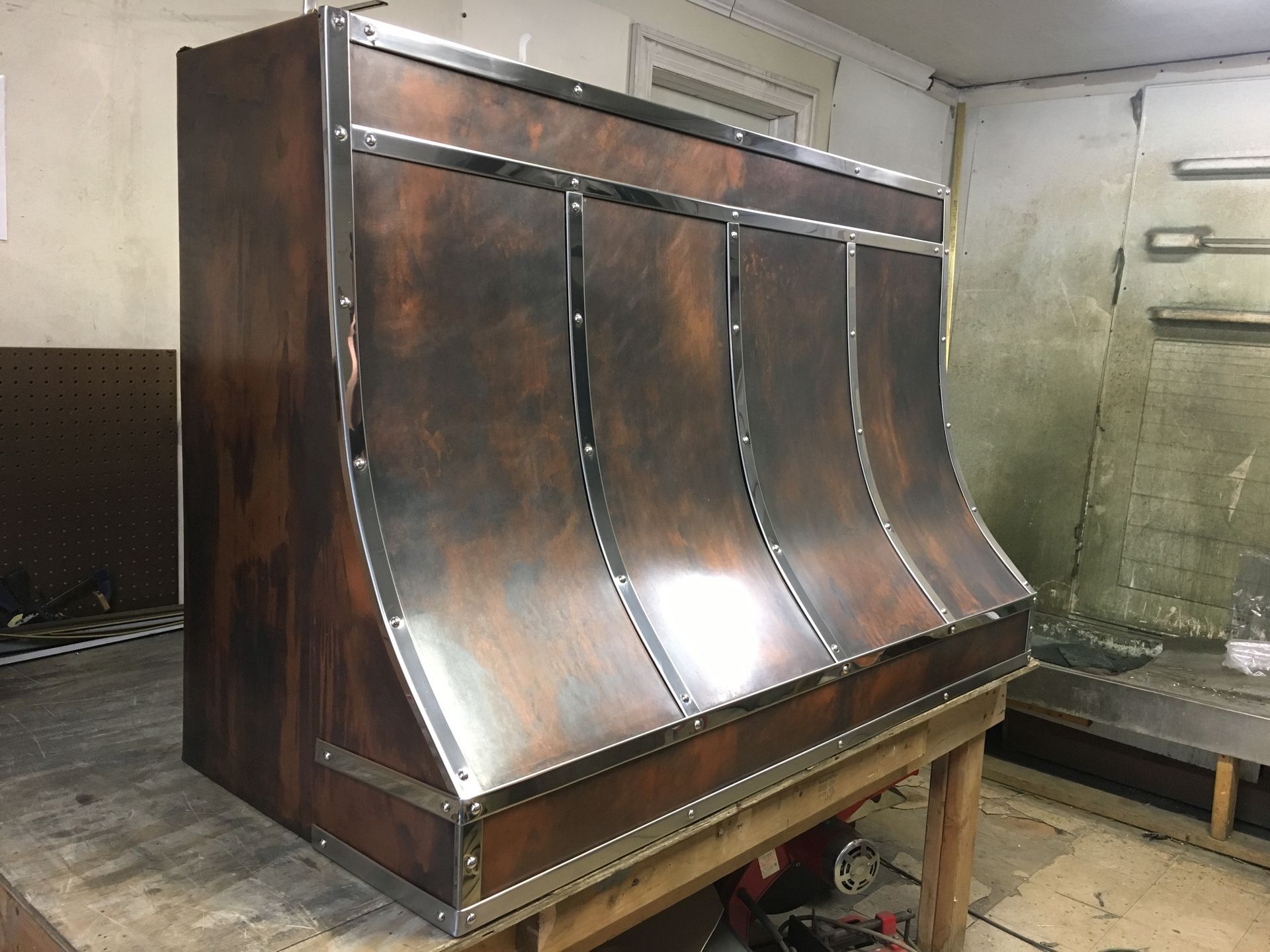 A wooden cabinet is sitting on top of a wooden table in a room.