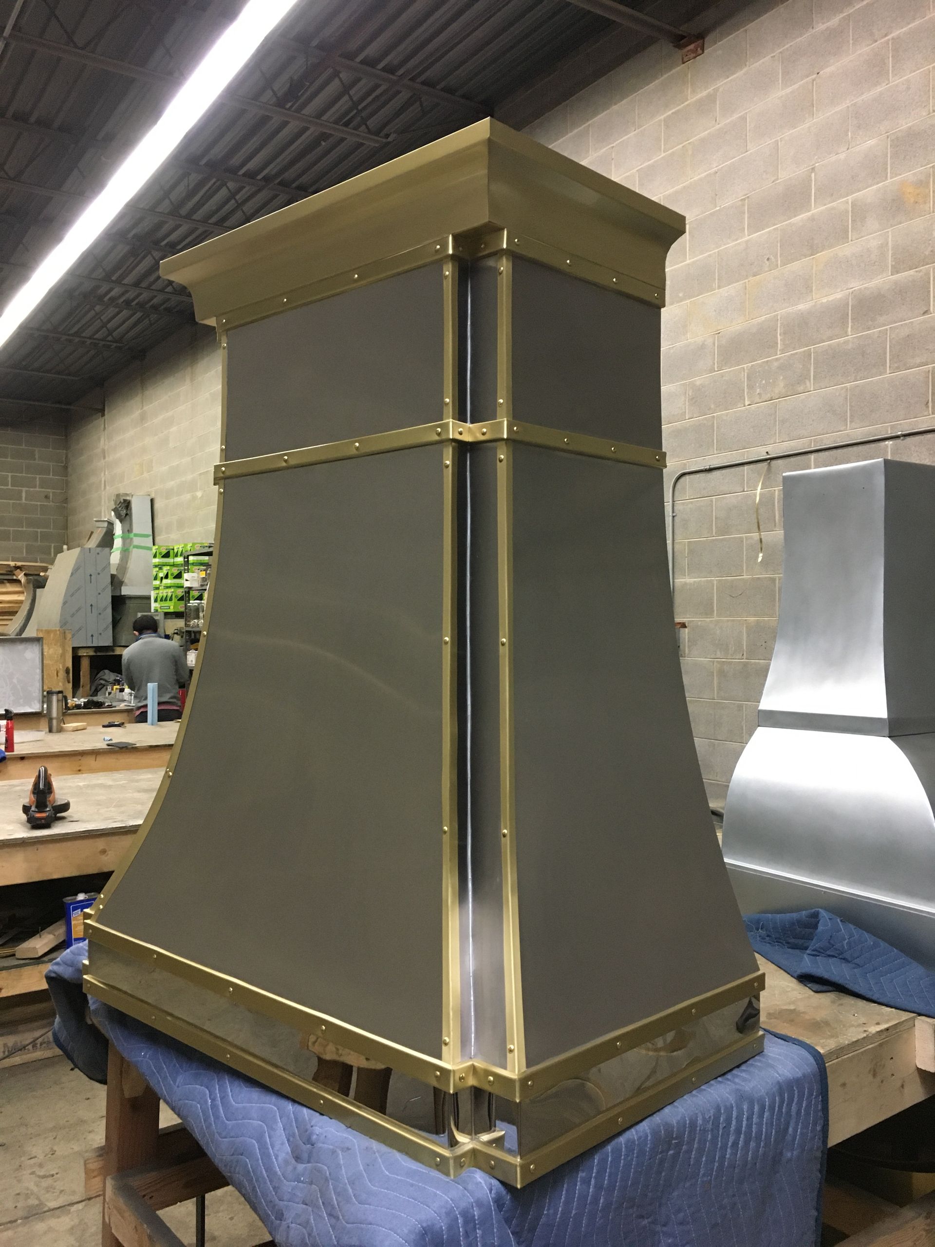 A gray and gold hood is sitting on a blue table