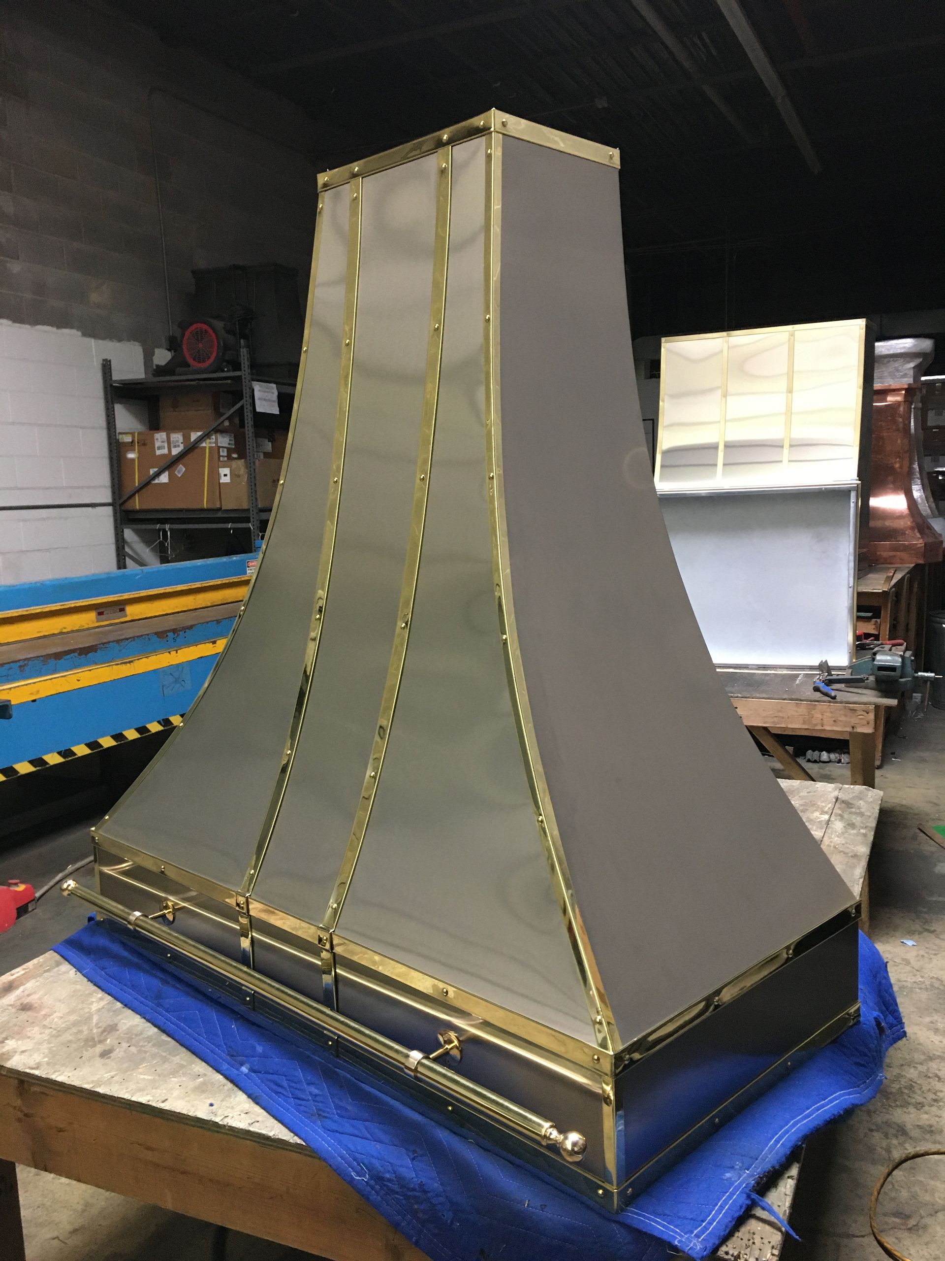 A stainless steel hood is sitting on top of a wooden table.