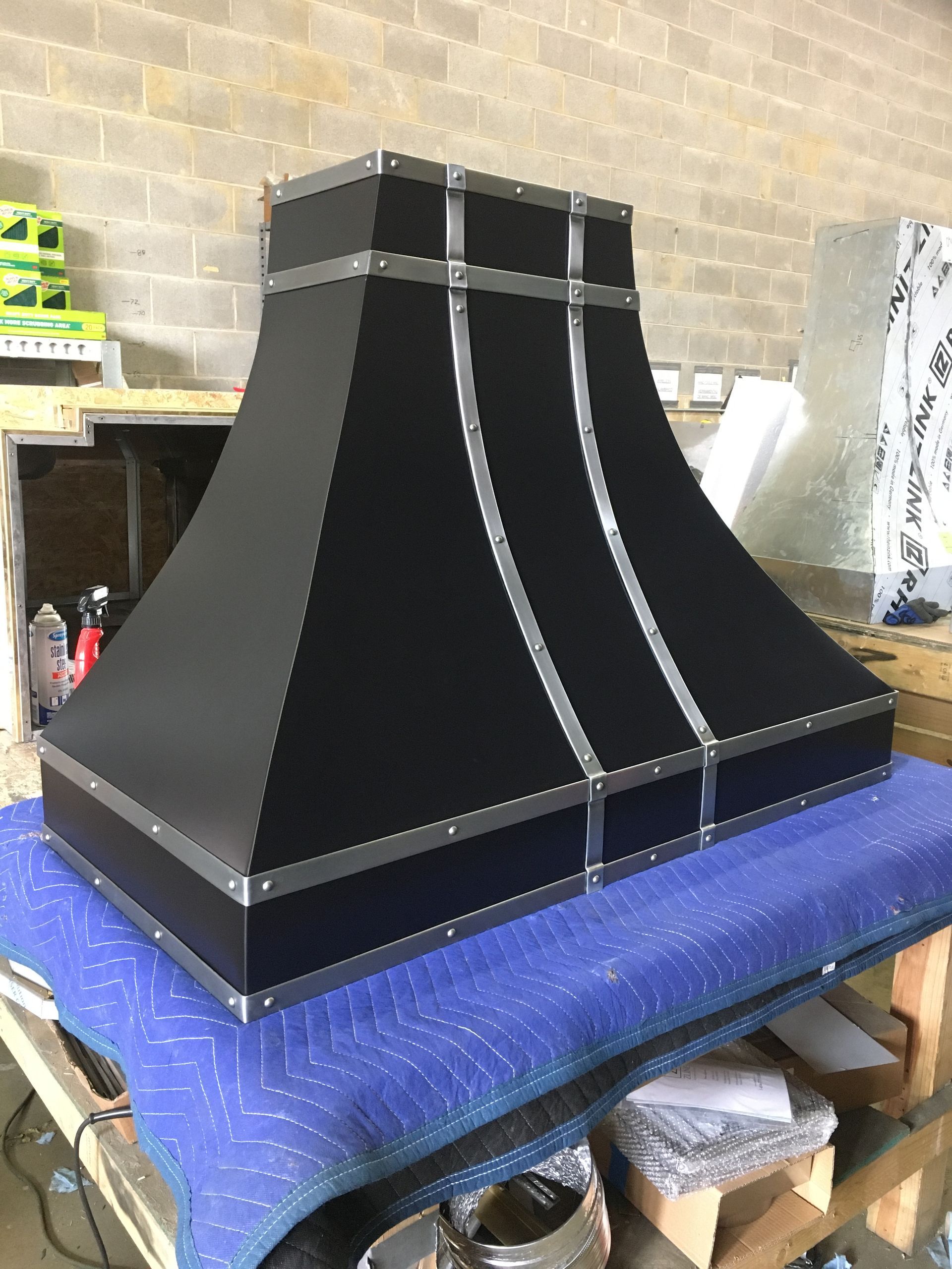 A black hood is sitting on top of a blue table.