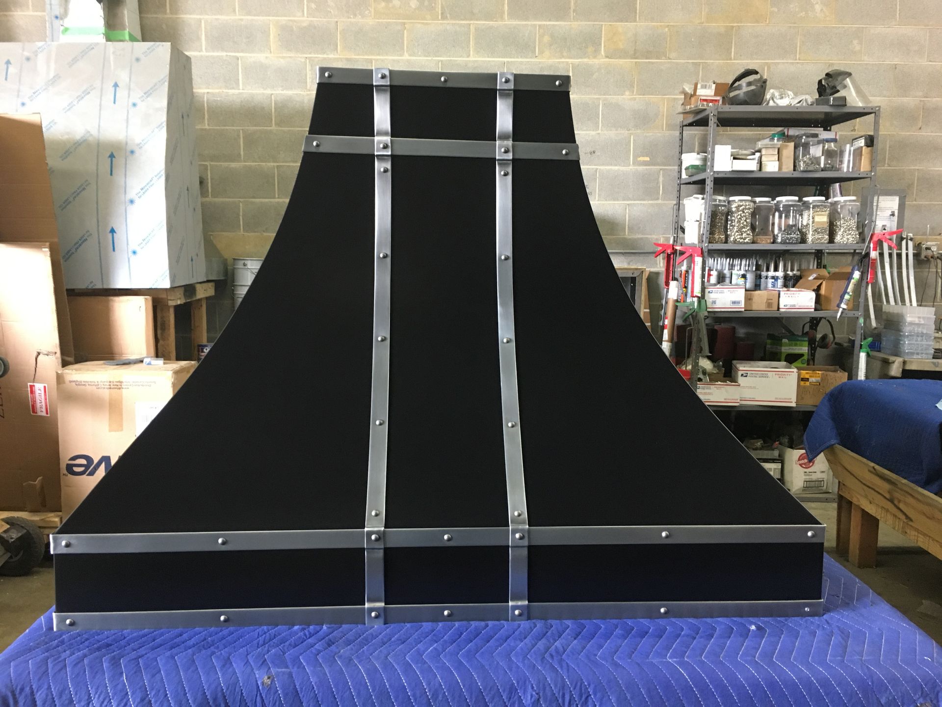 A black hood is sitting on top of a blue table.