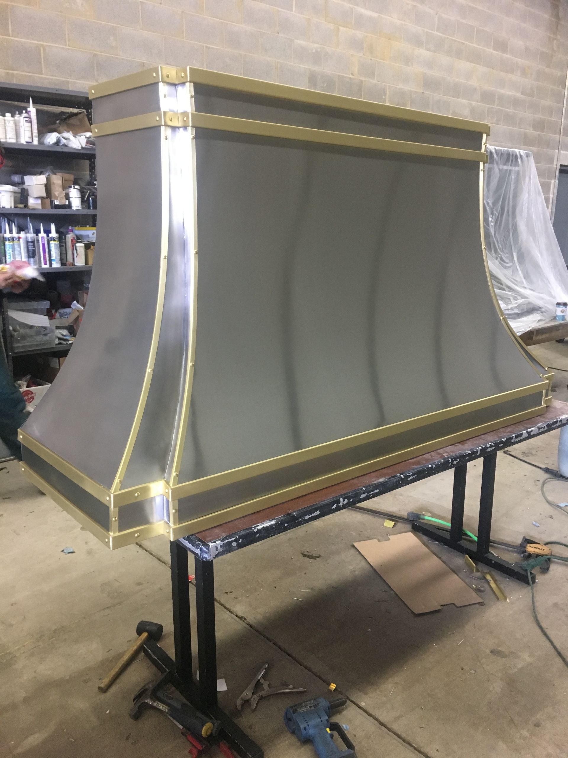 A stainless steel hood is sitting on top of a wooden table.