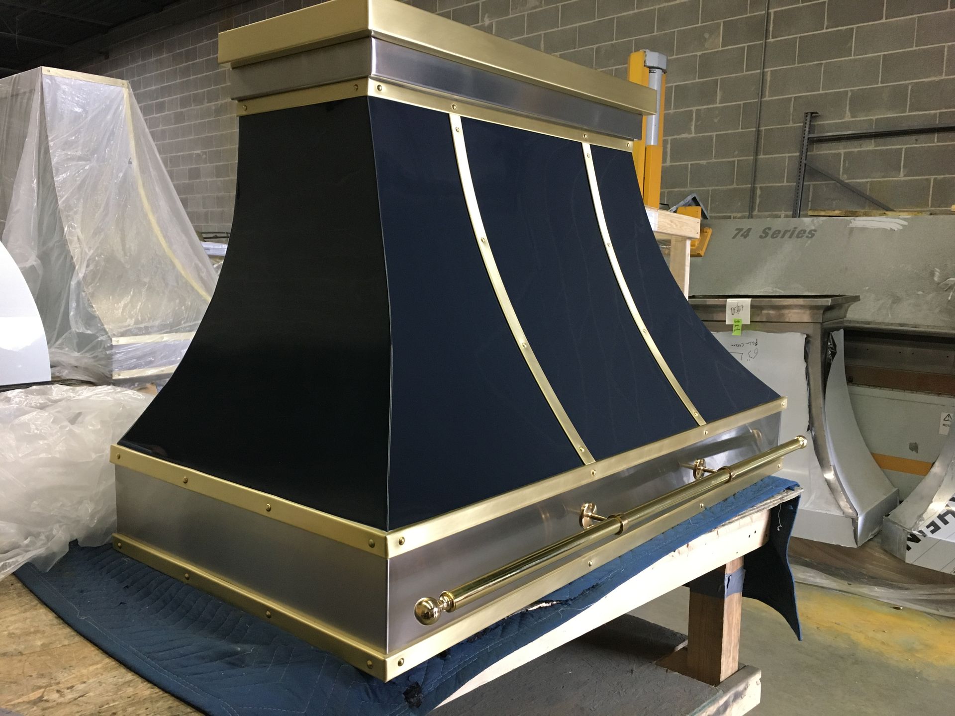 A black and gold hood is sitting on a wooden table.