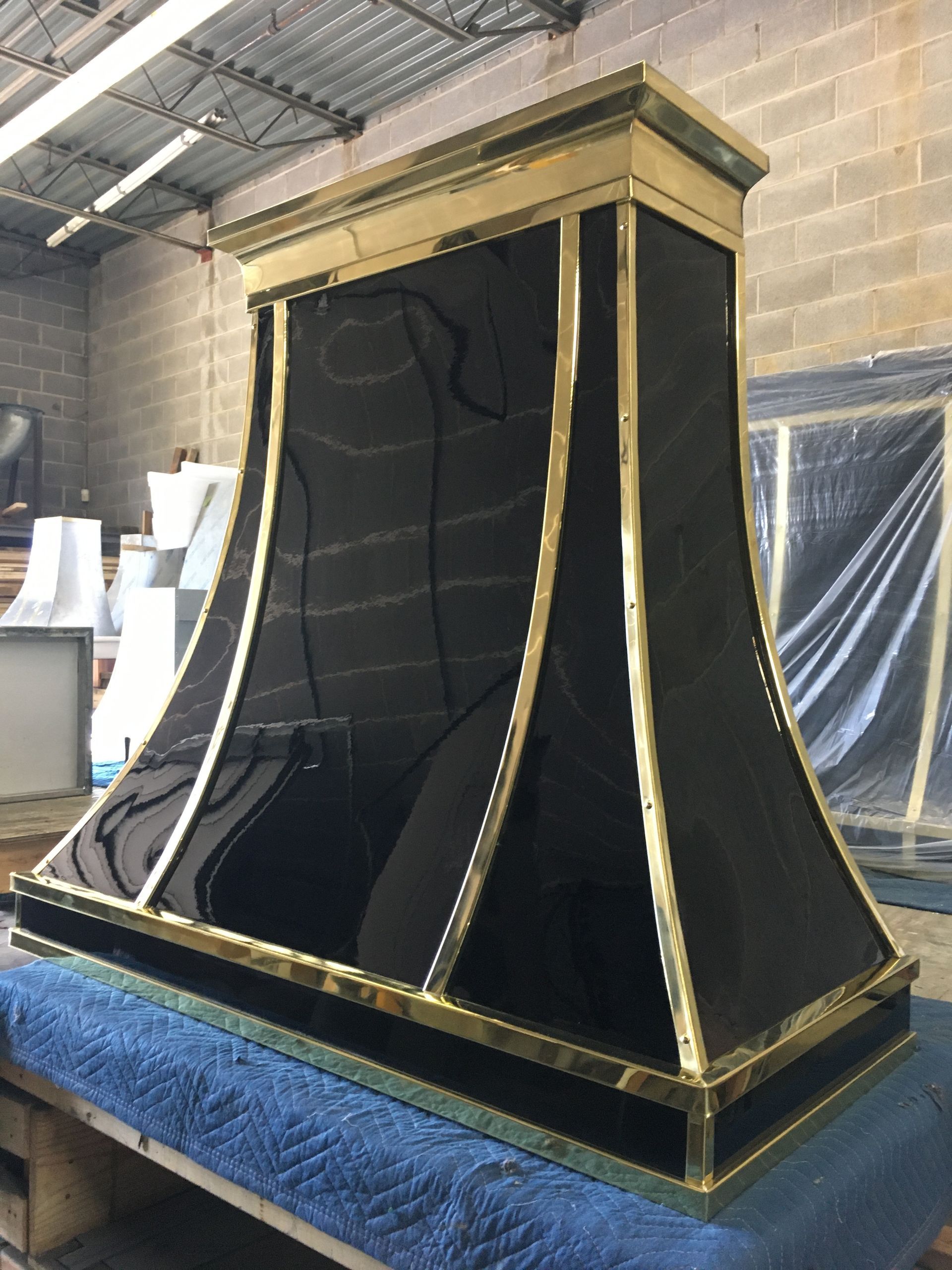 A black and gold hood is sitting on top of a blue table.