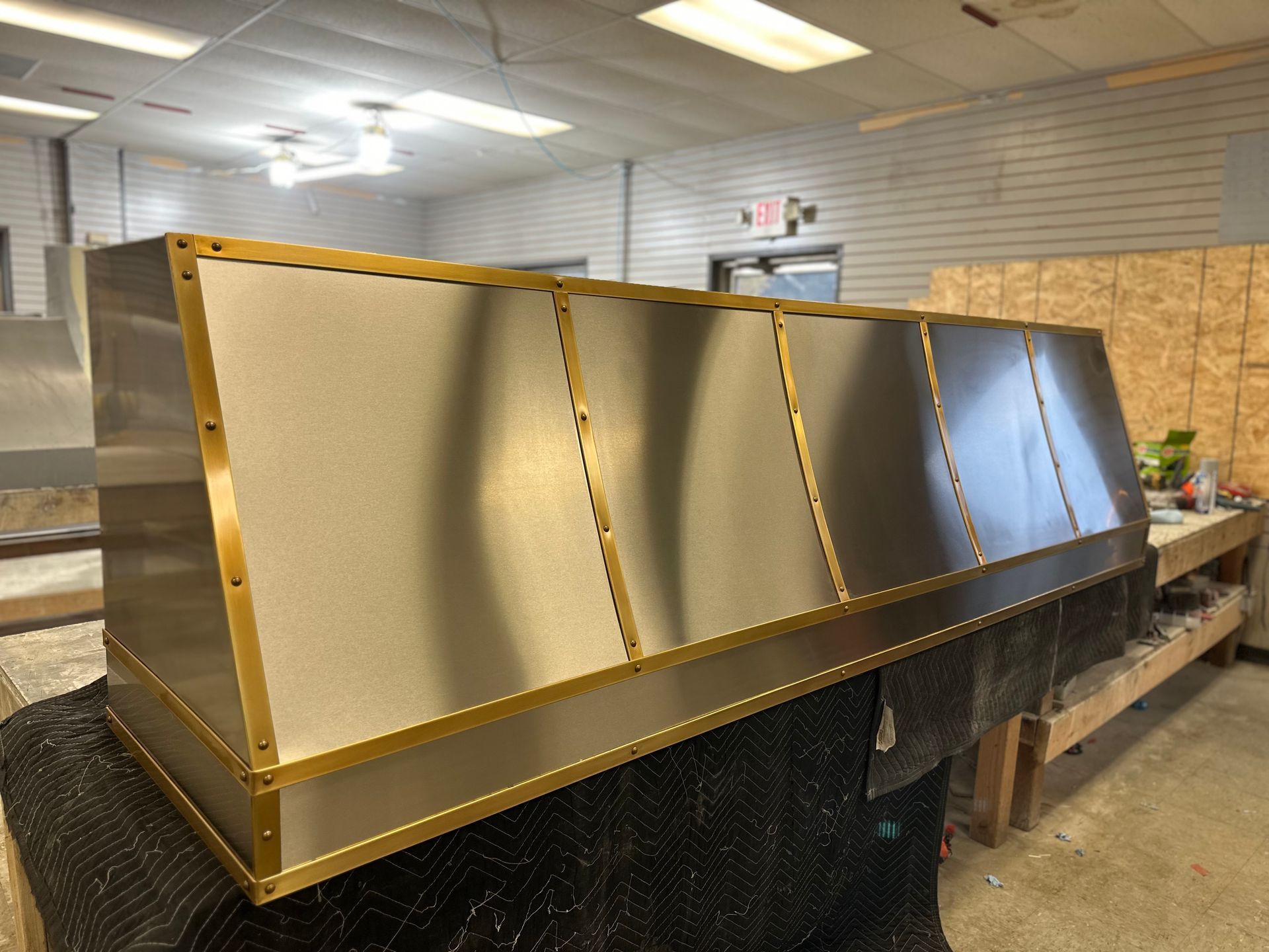 A stainless steel hood is sitting on a table in a room.