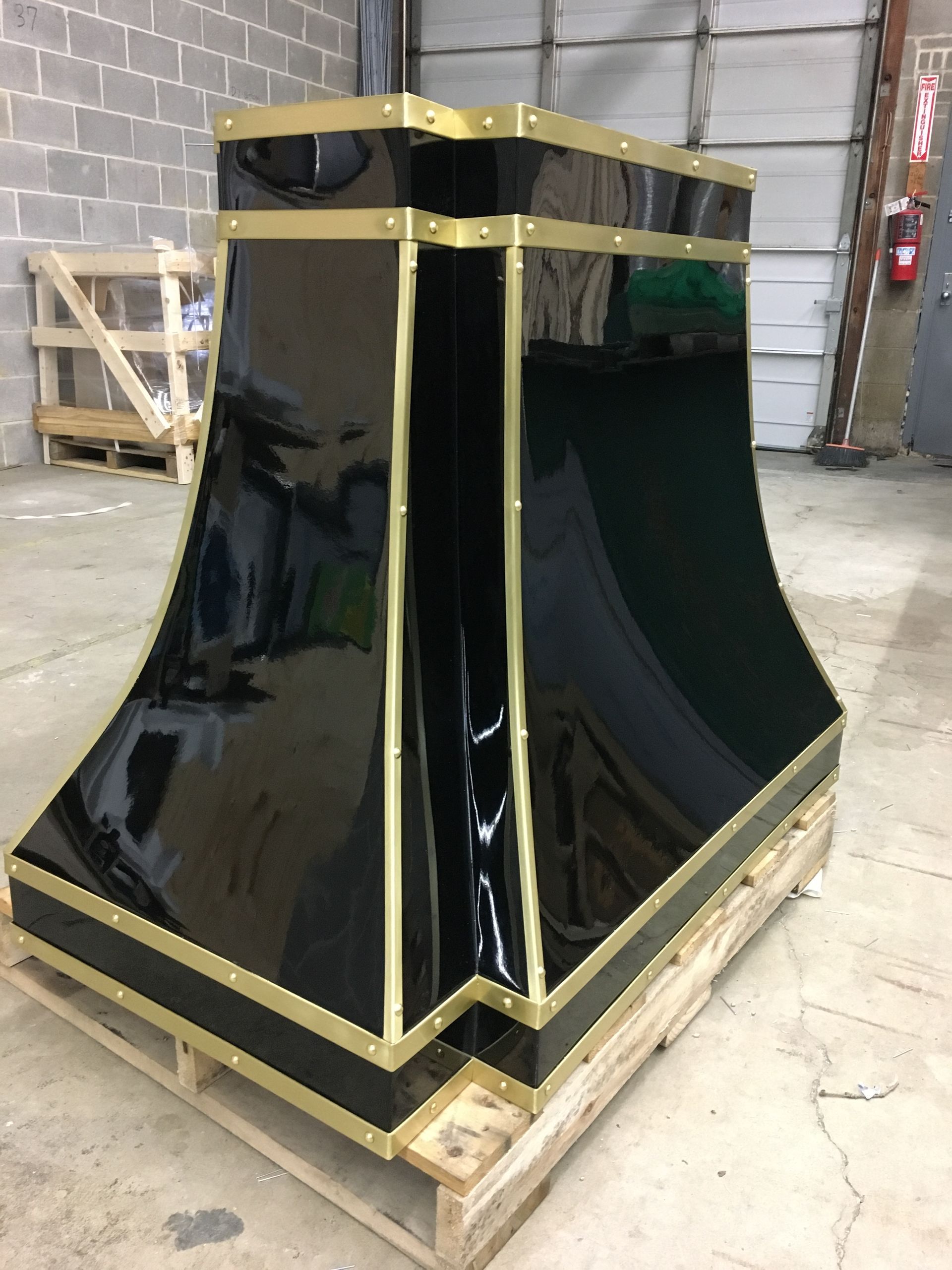 A black and gold item is sitting on a wooden pallet