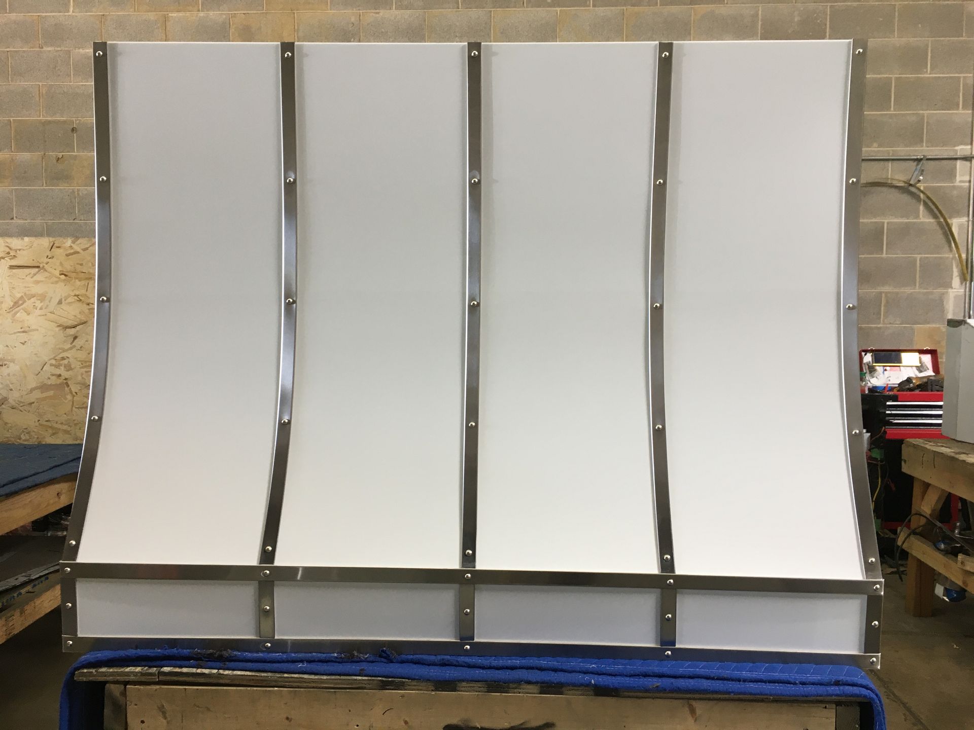 A white wall with a stainless steel frame is sitting on top of a wooden table.