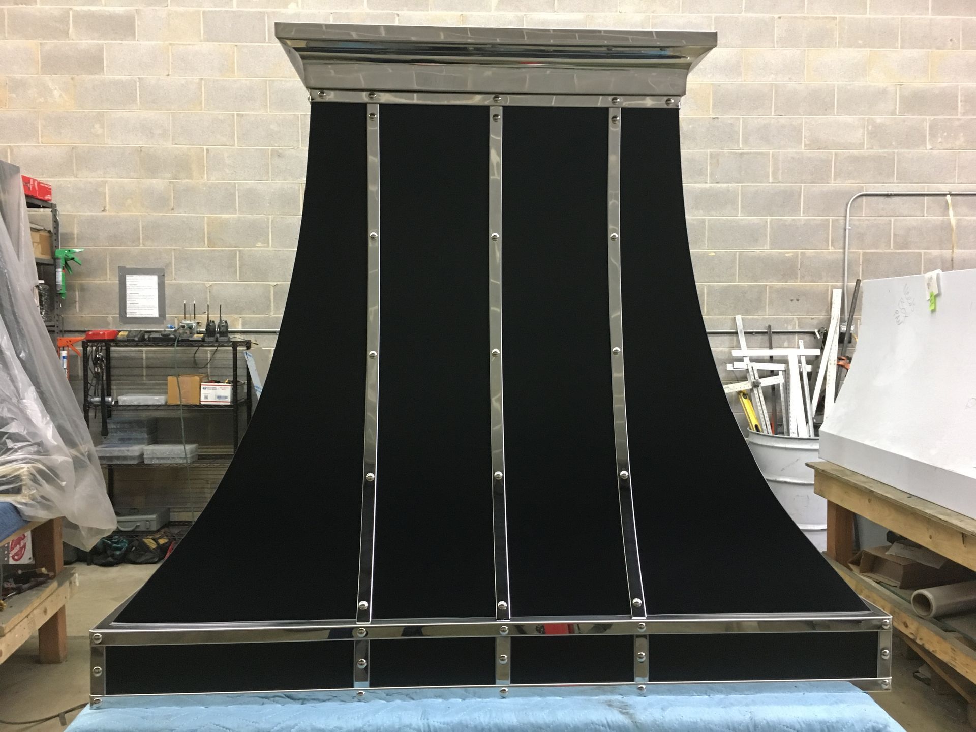 A black hood is sitting on top of a blue table in a room.