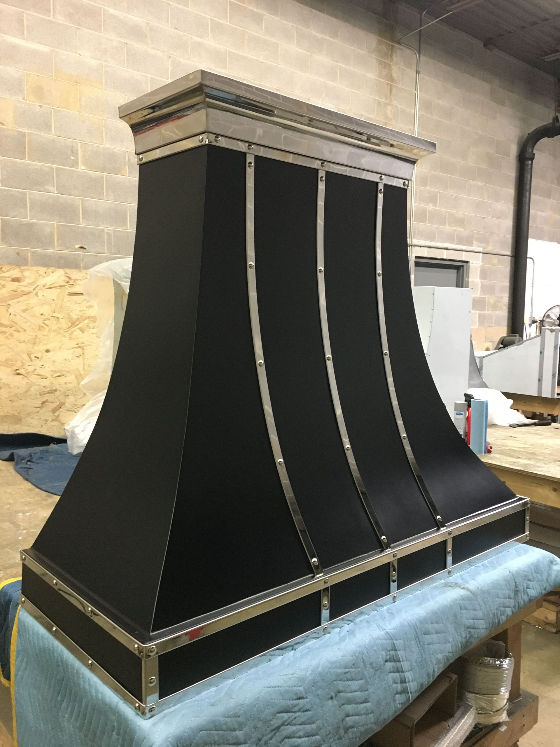 A black hood is sitting on top of a blue table in a room.