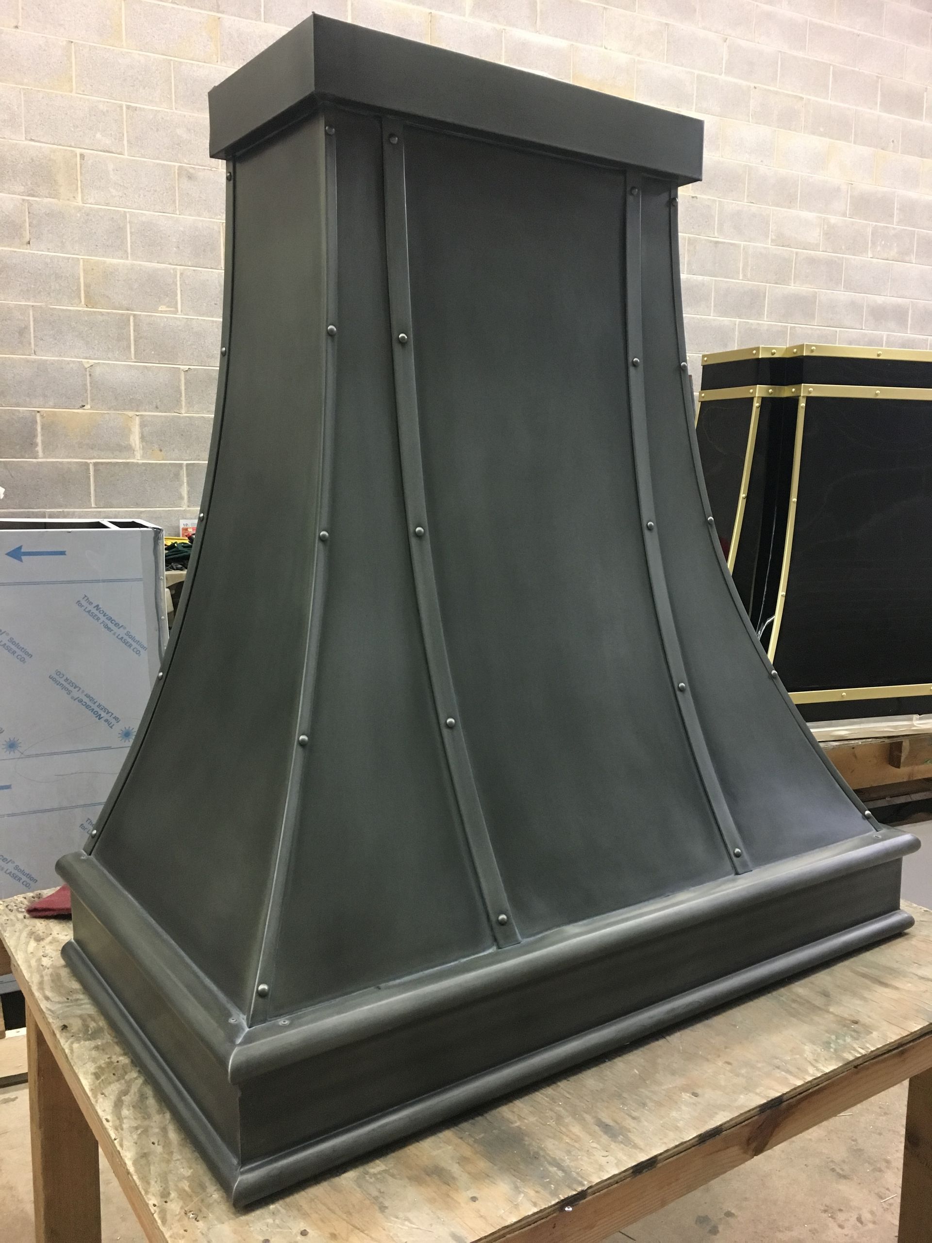 A black hood is sitting on top of a wooden table.