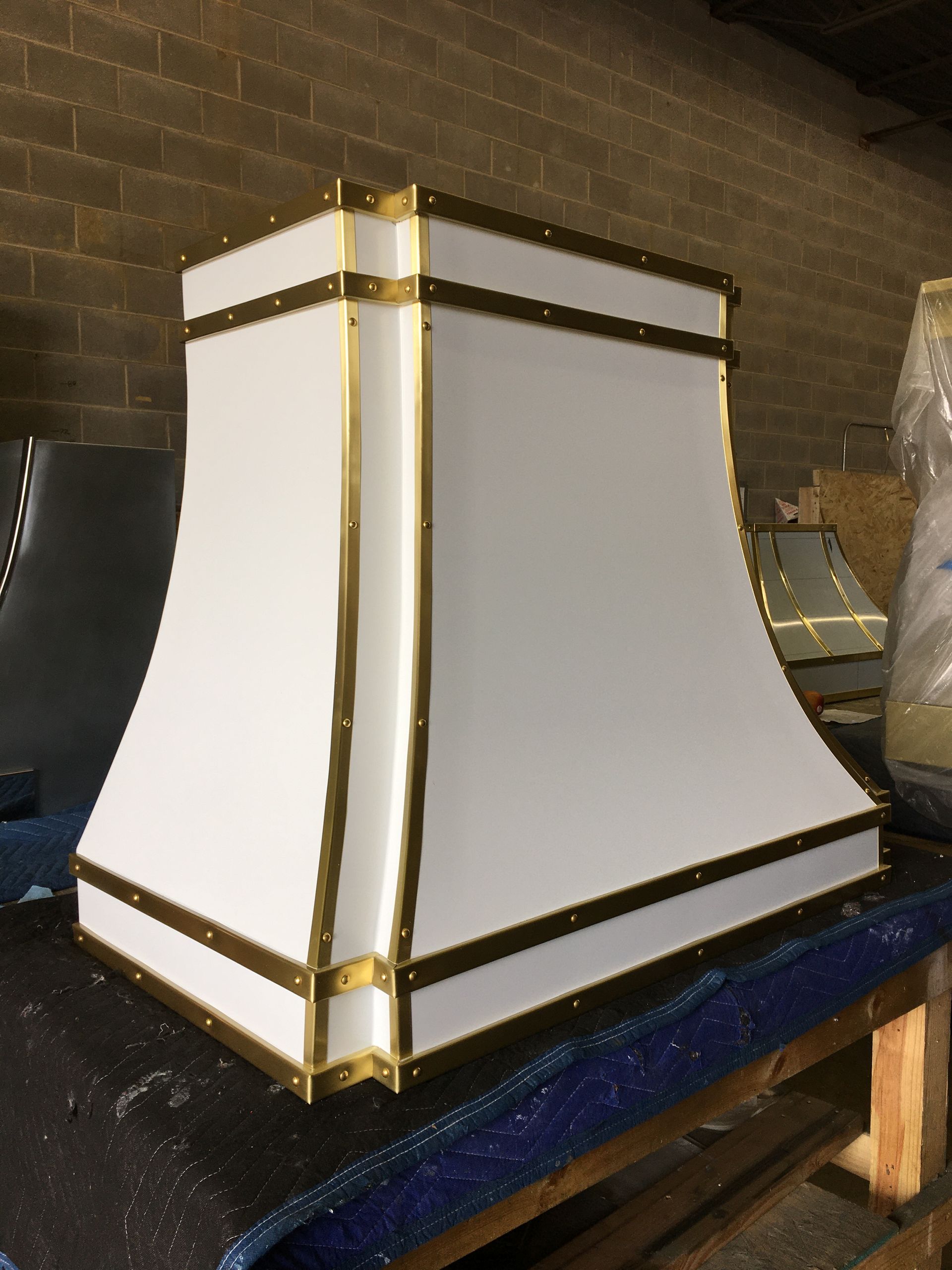 A white lampshade with gold trim sits on a table