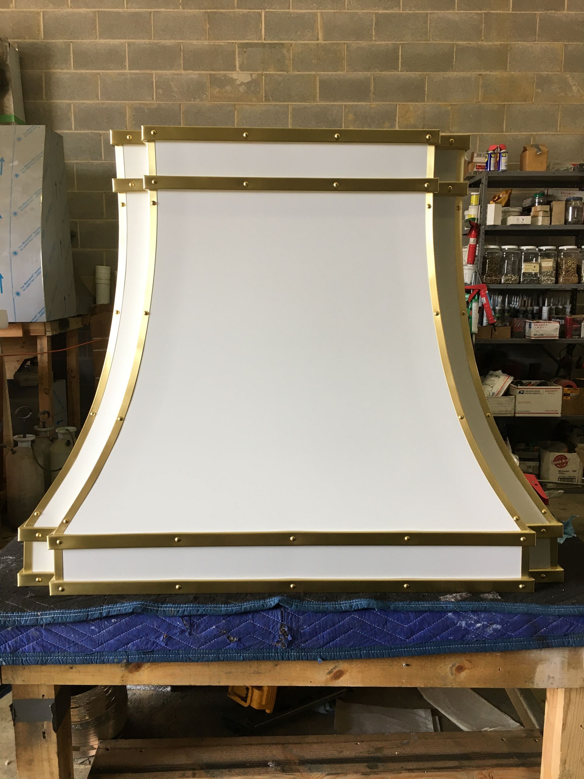 A white and gold hood is sitting on a wooden table.
