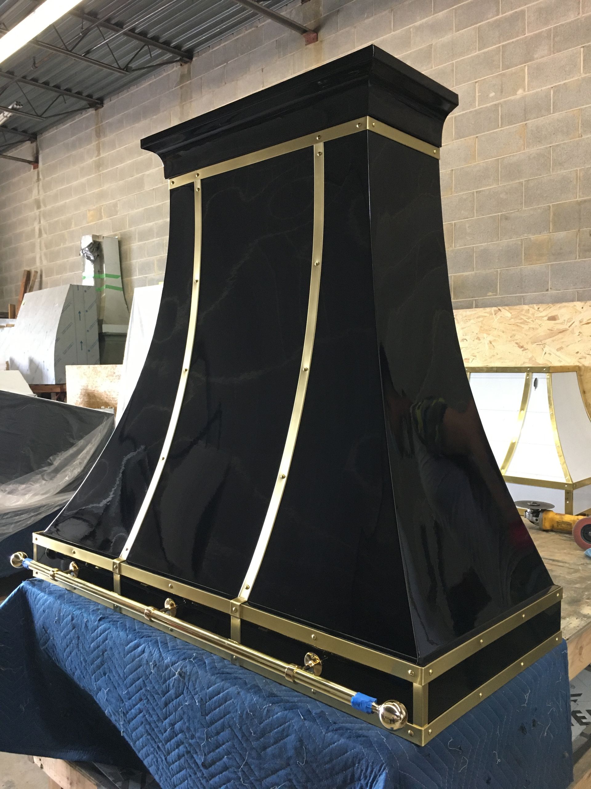 A black and gold hood is sitting on top of a blue blanket.