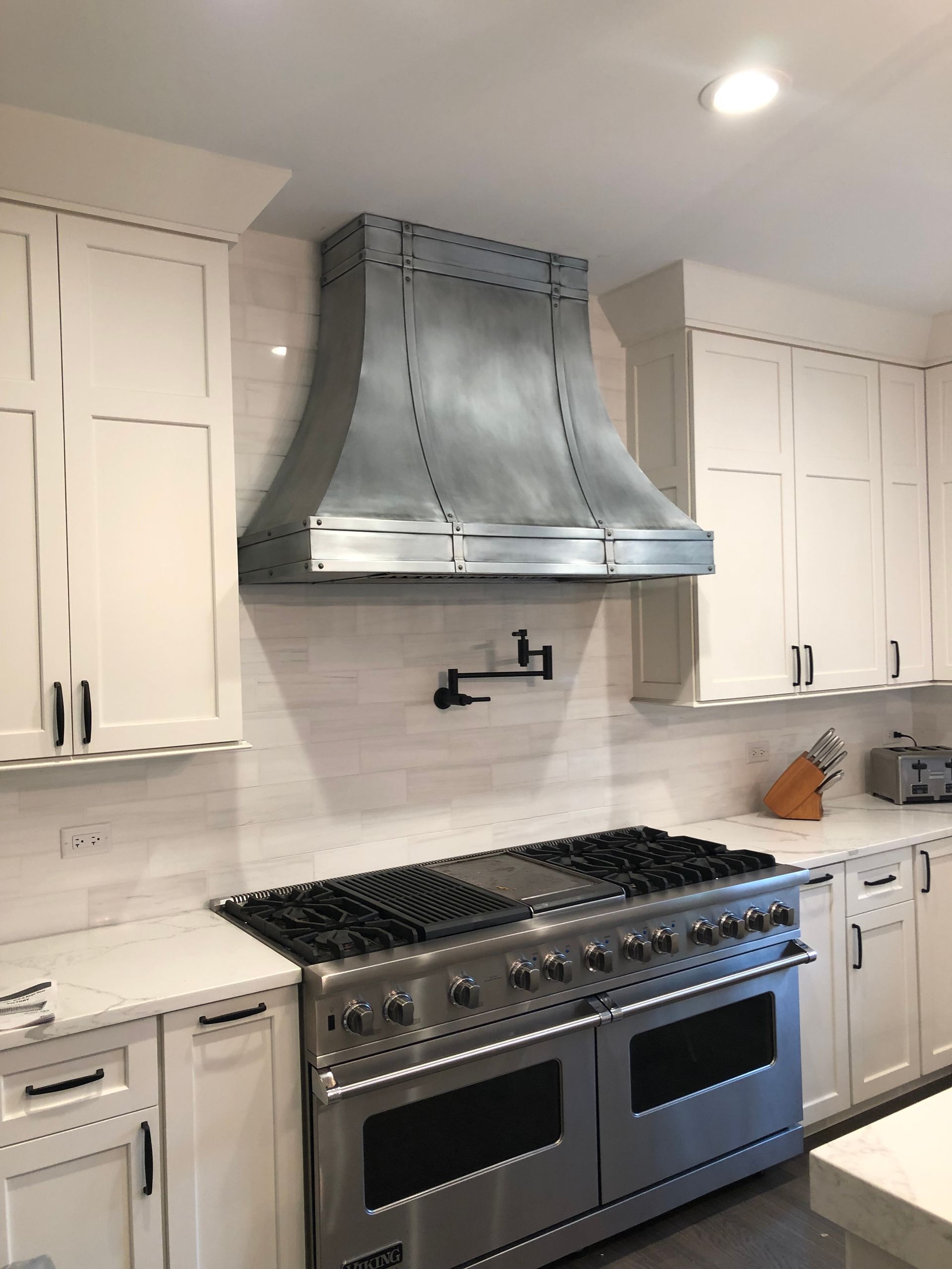 A kitchen with stainless steel appliances and white cabinets
