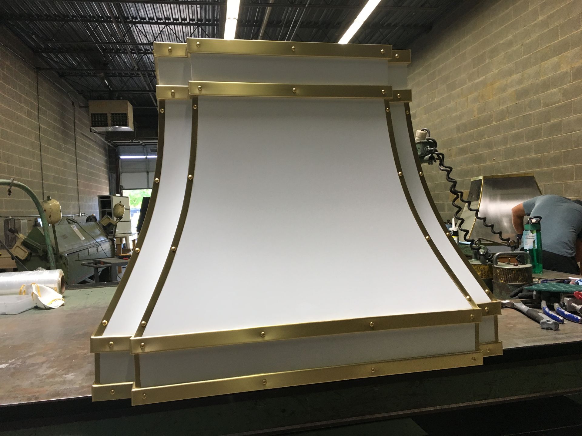 A white and gold hood is sitting on a table in a room.