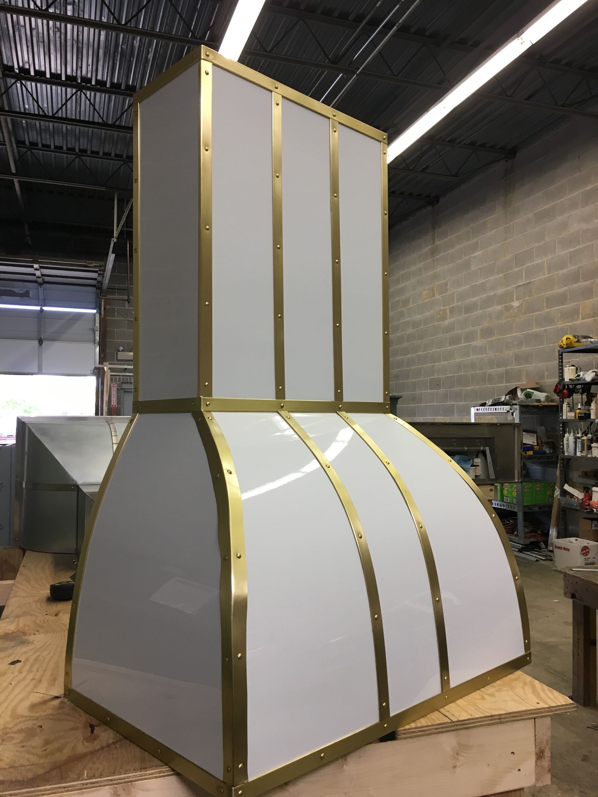 A white and gold hood is sitting on top of a wooden table.