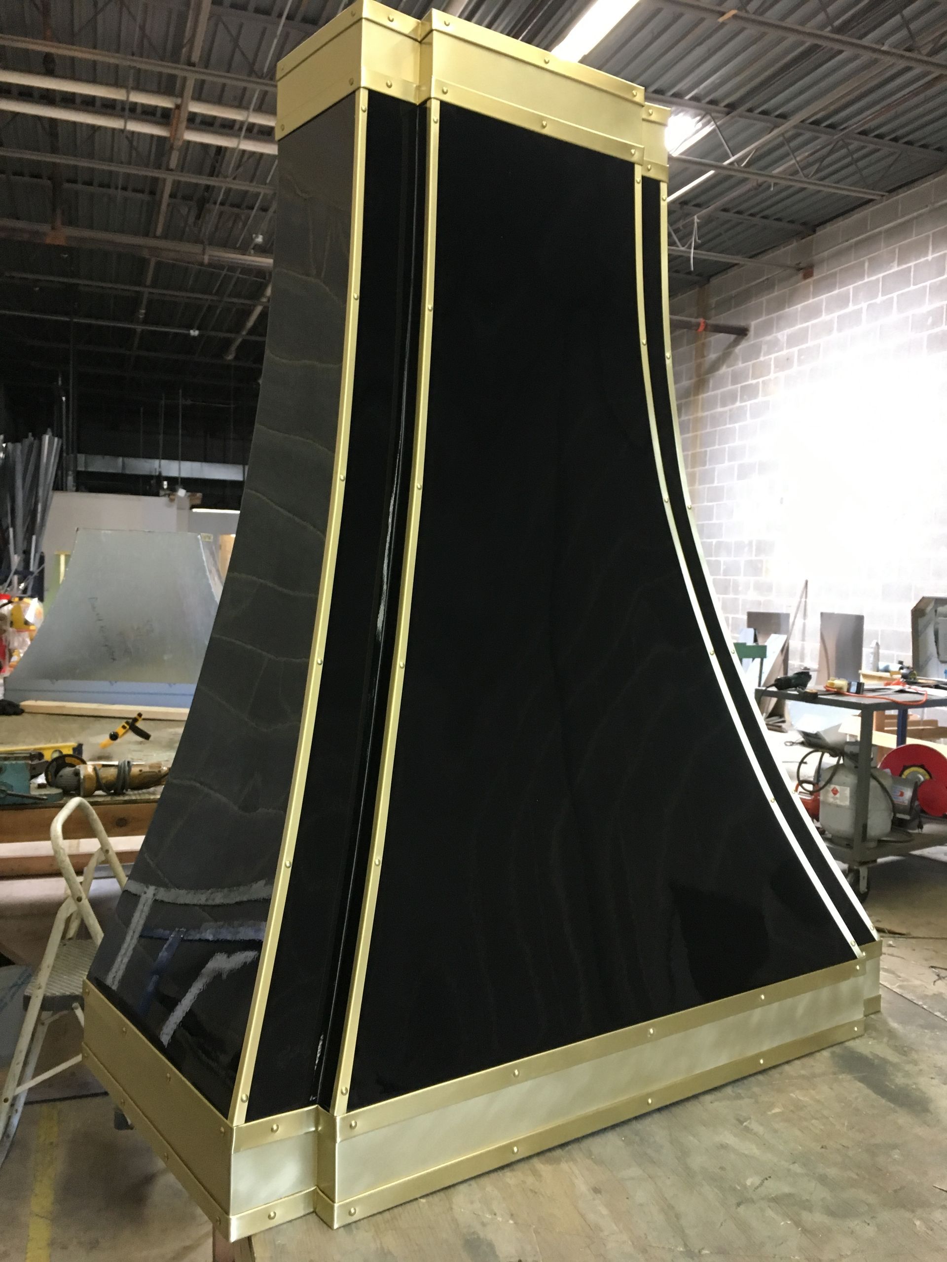 A black and gold item is sitting on a wooden floor