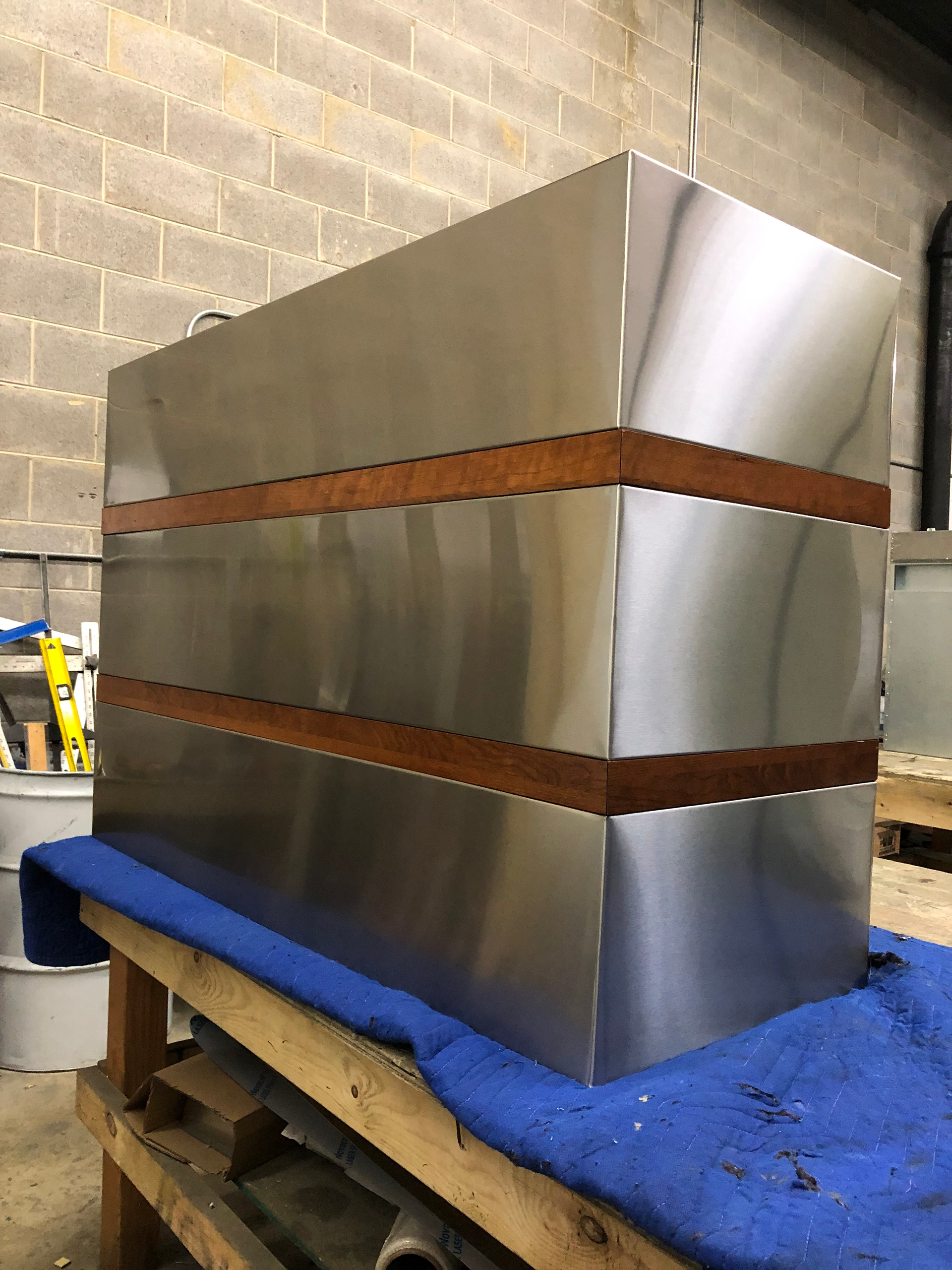 A stainless steel box is sitting on top of a wooden table.