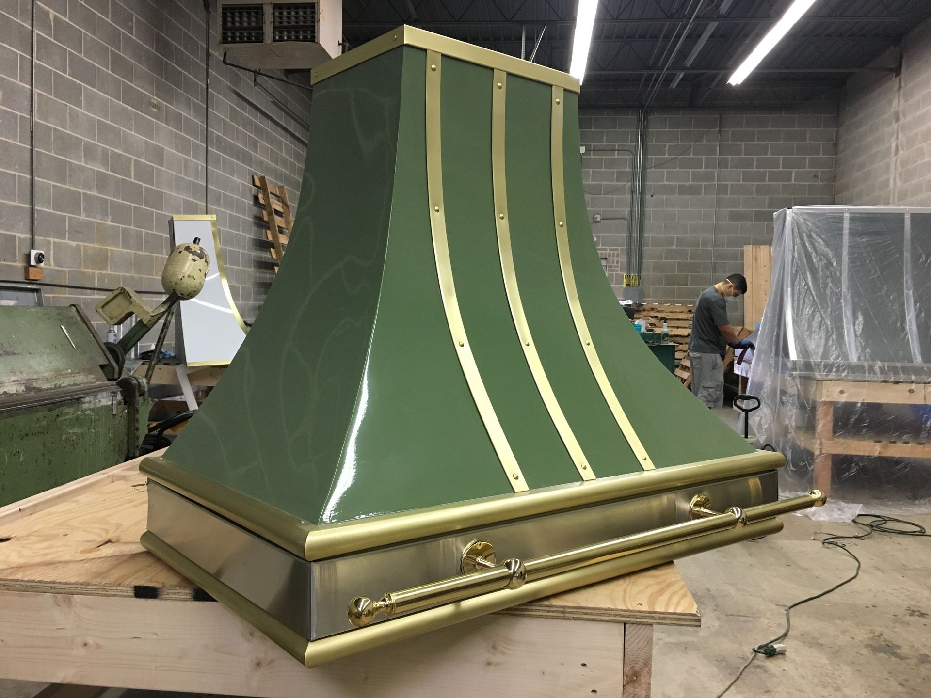 A green and gold hood is sitting on a wooden table in a room.