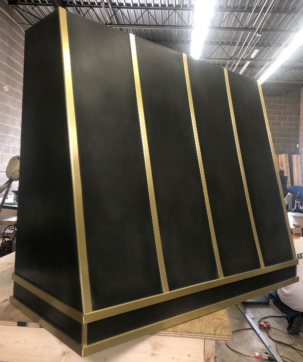 A black box with gold stripes is sitting on a wooden table.