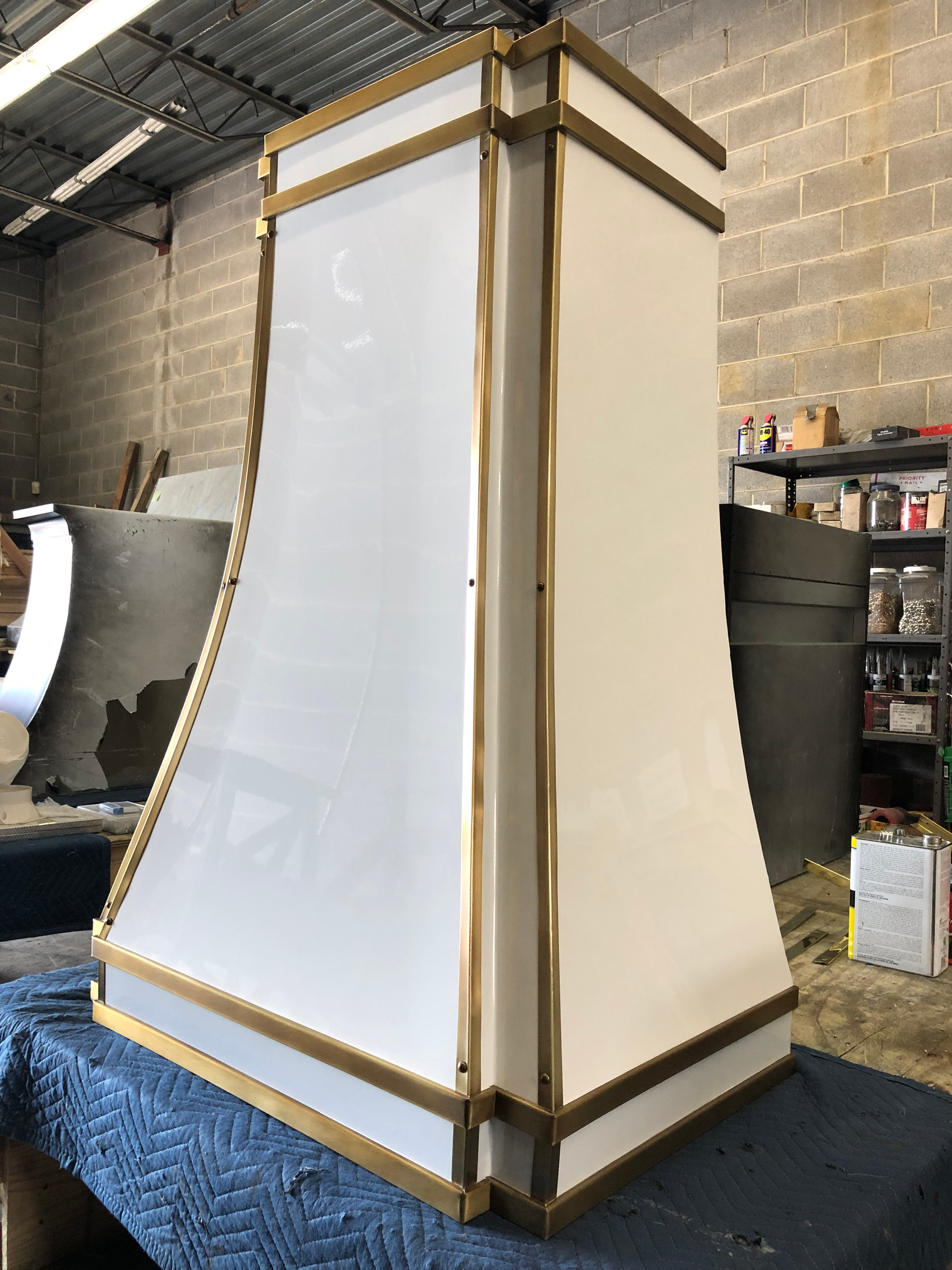 A white and gold hood is sitting on top of a blue table.