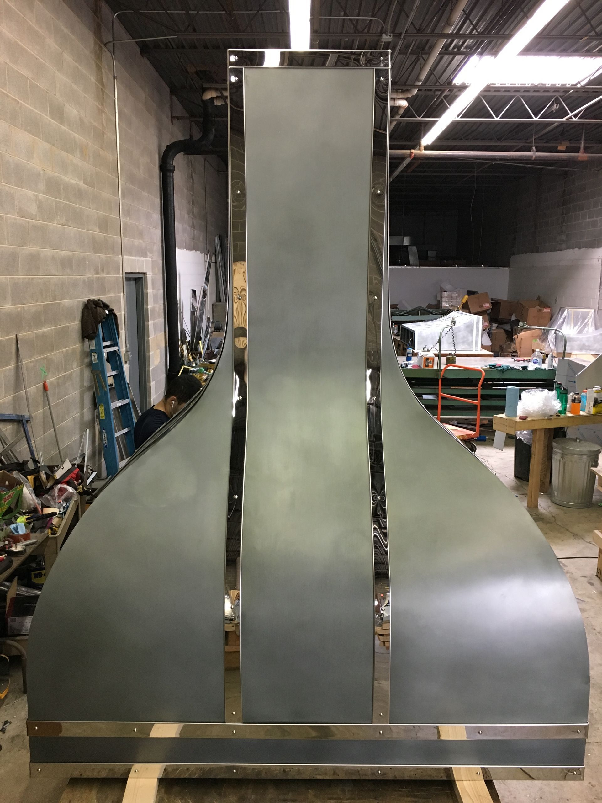 A large metal sculpture is sitting on top of a wooden table in a room.