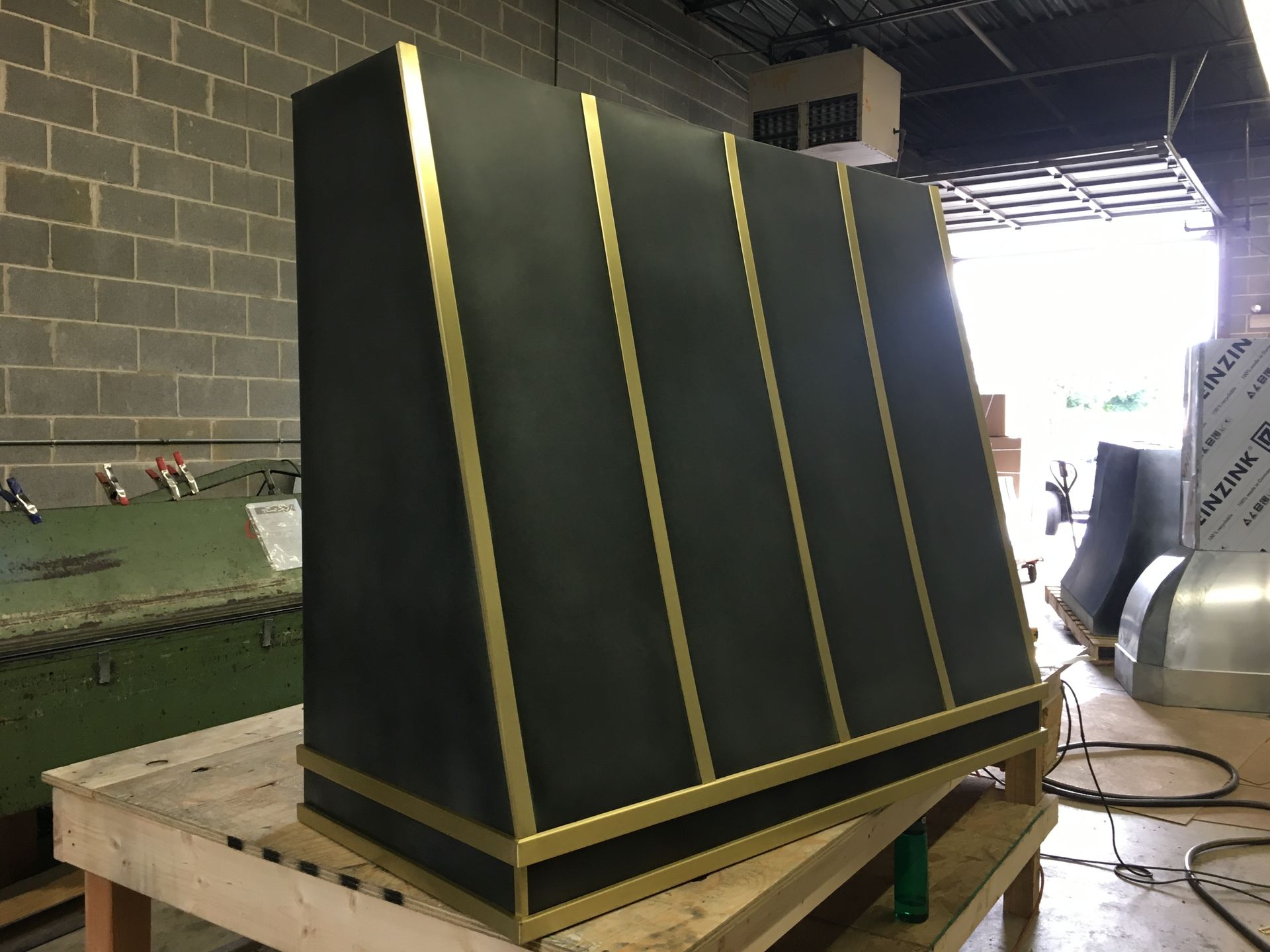 A black and gold cabinet is sitting on top of a wooden table.