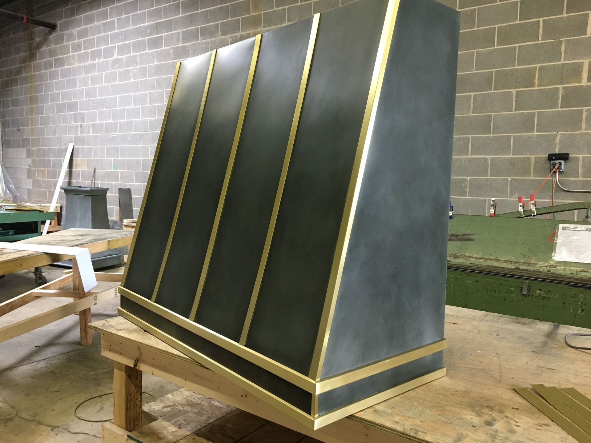 A black and gold cabinet is sitting on top of a wooden table.