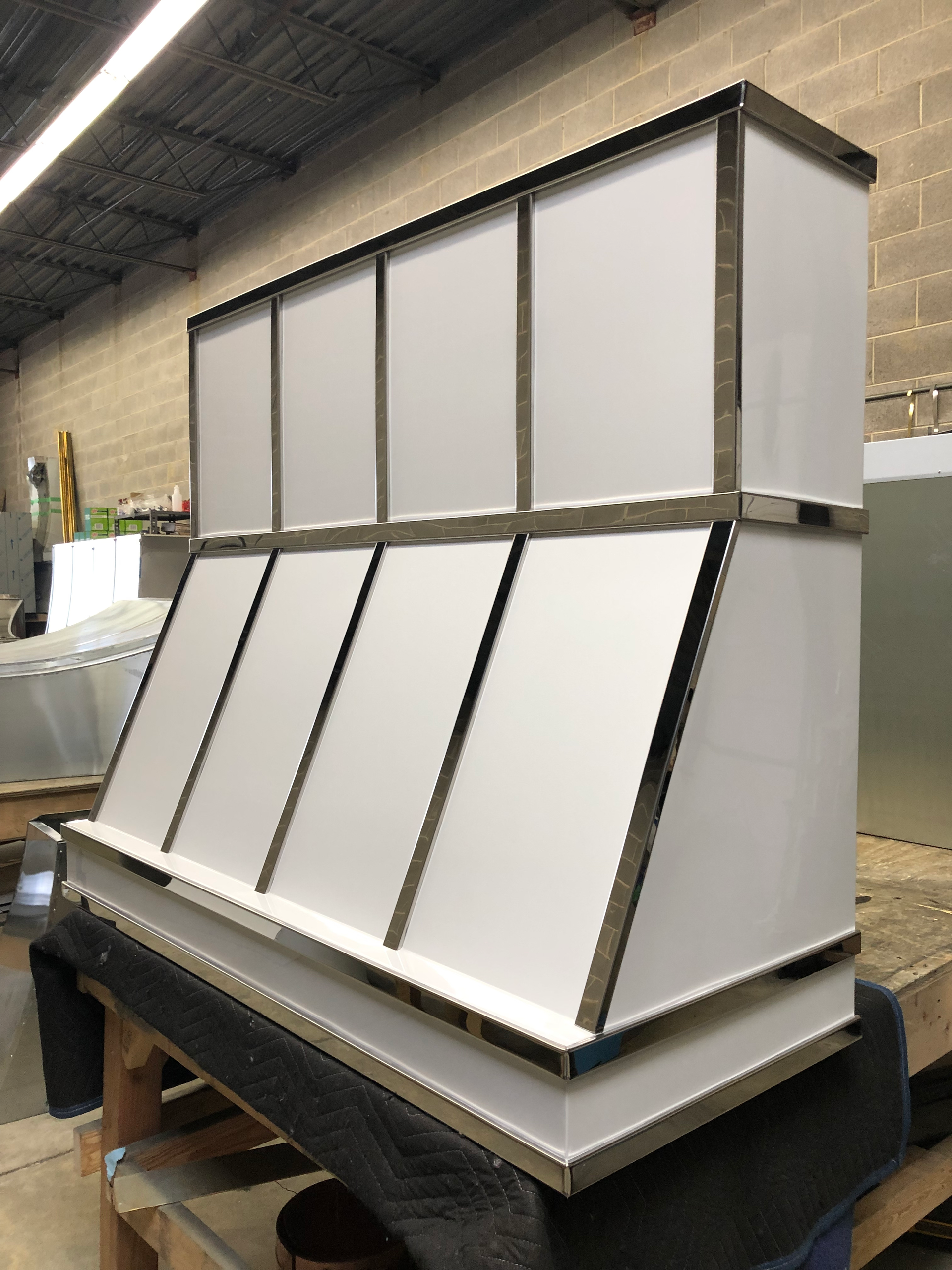 A stainless steel hood is sitting on top of a wooden table.
