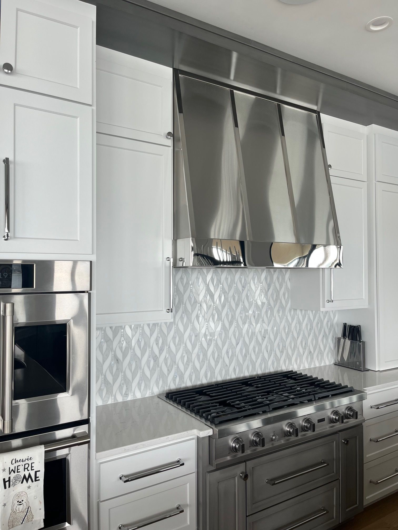 A kitchen with stainless steel appliances and white cabinets