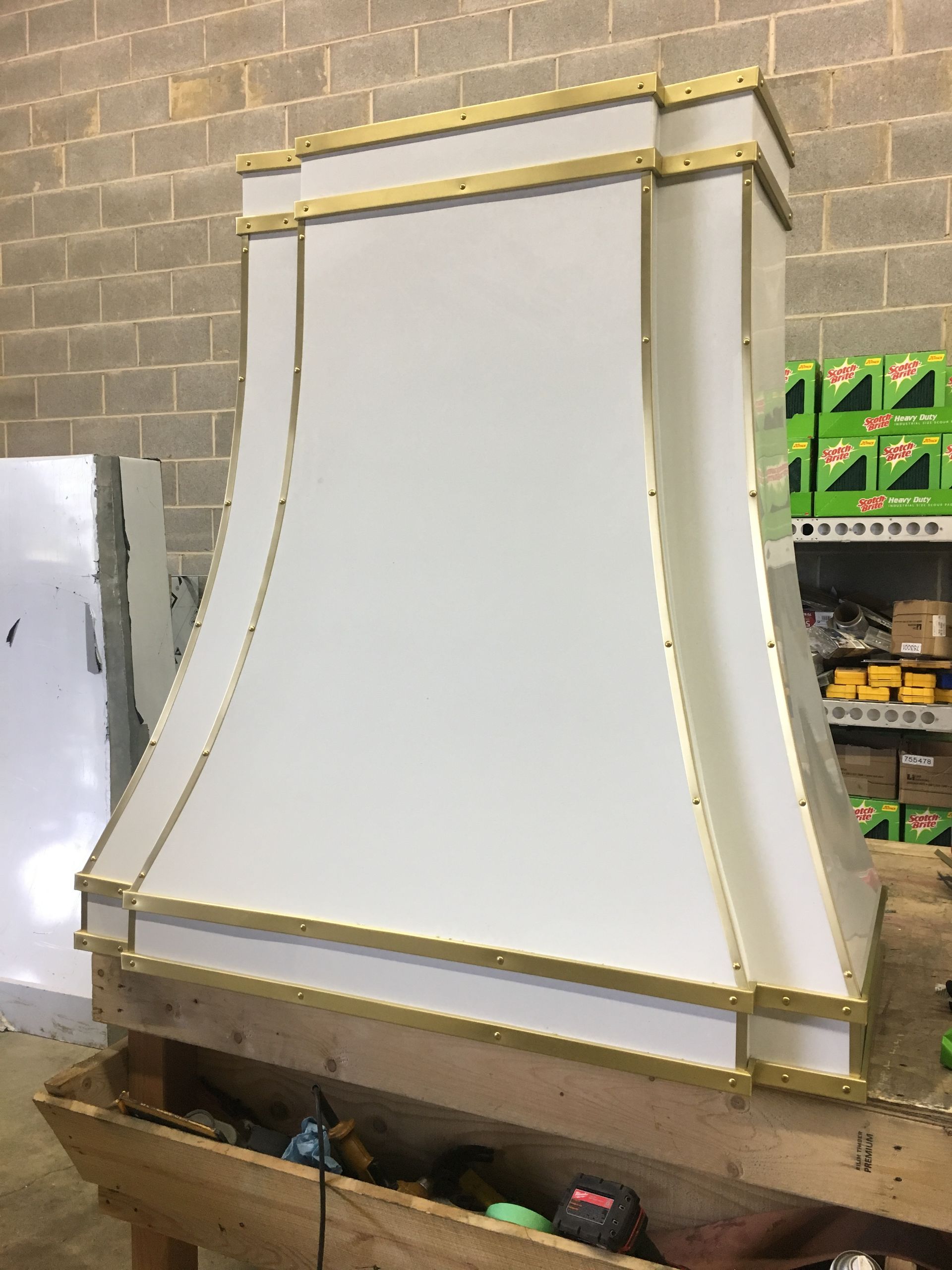 A white hood with gold trim is sitting on top of a wooden table.