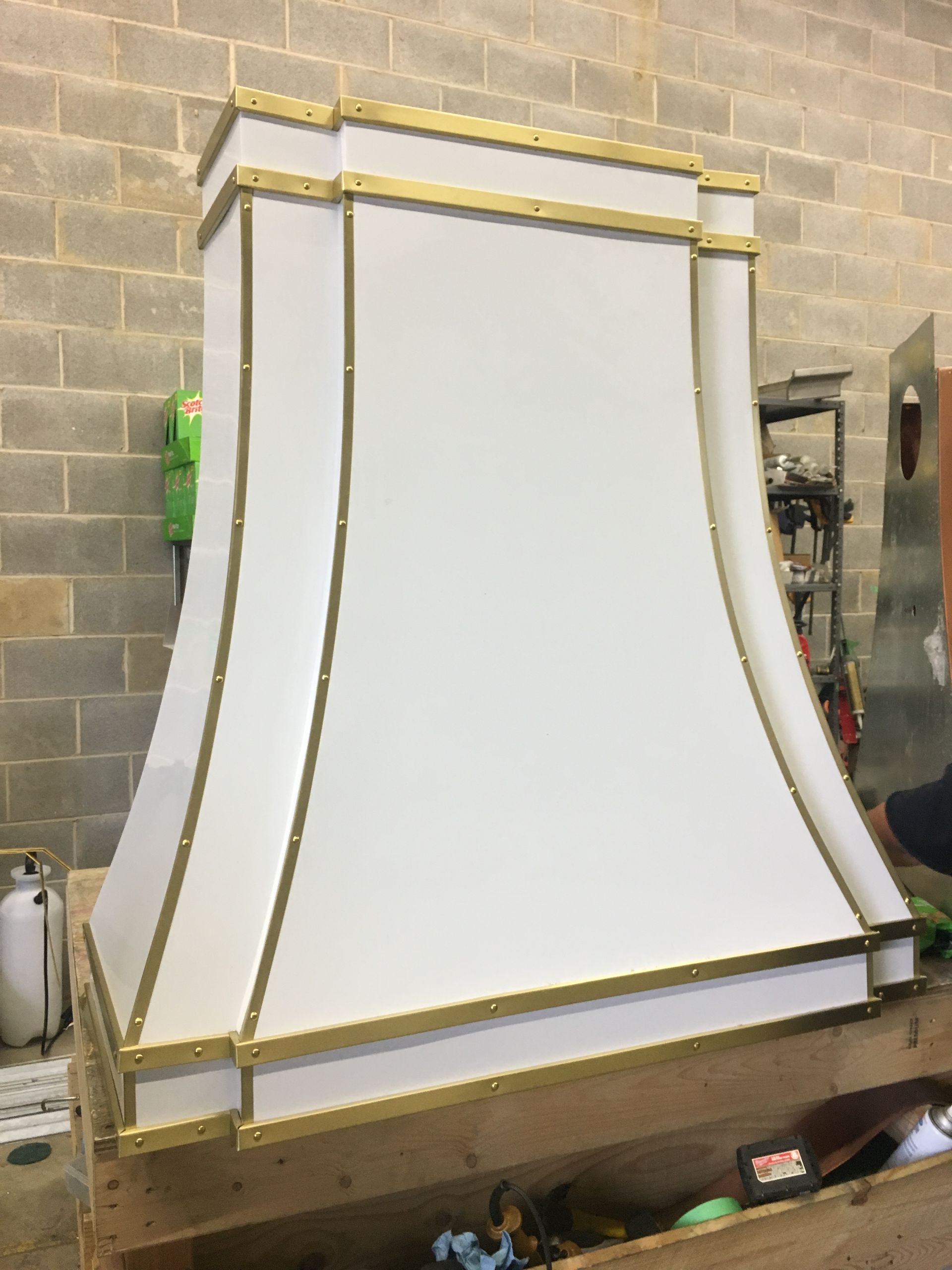 A white hood with gold trim is sitting on top of a wooden box.