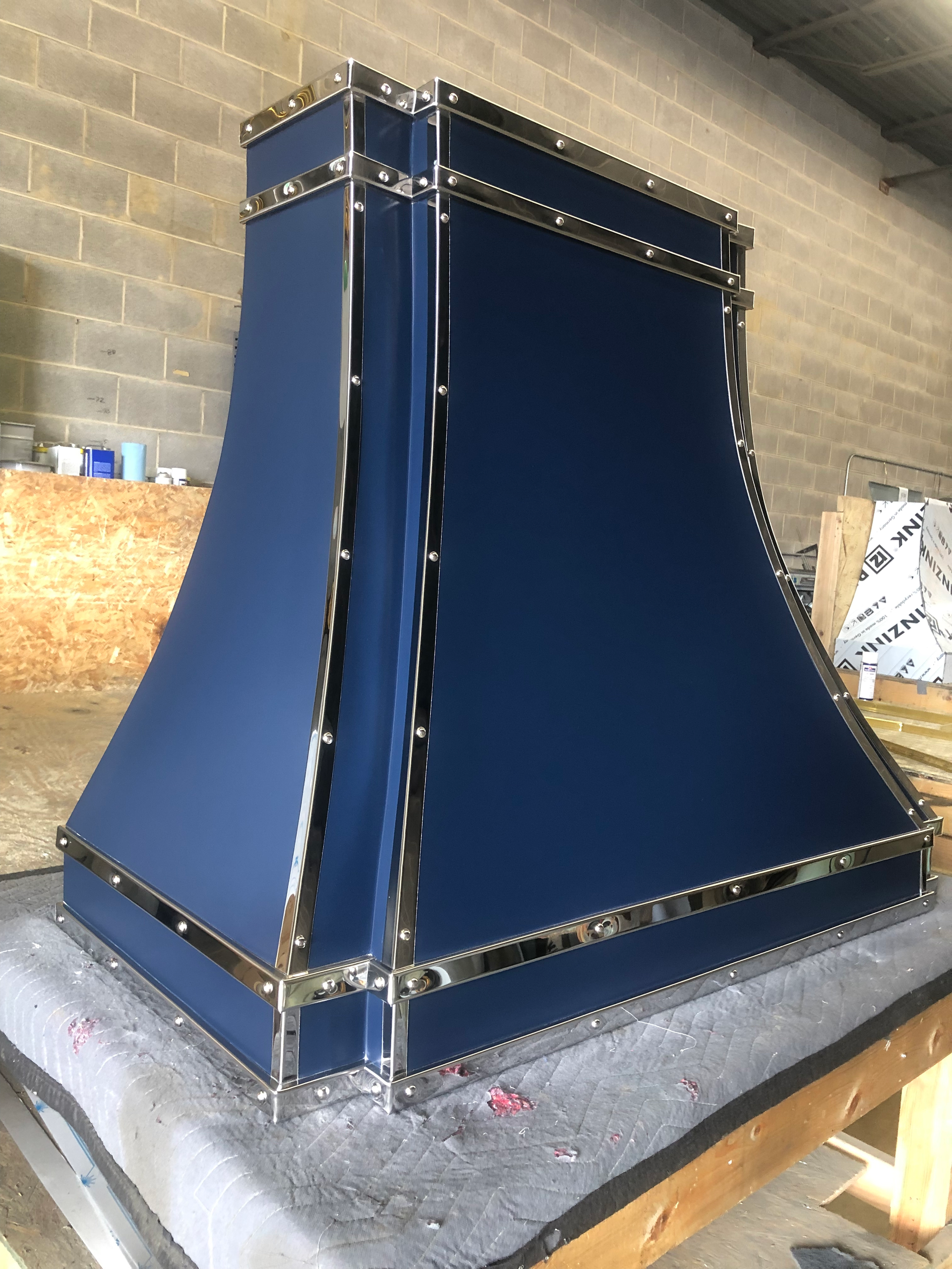 A blue hood is sitting on top of a wooden table.