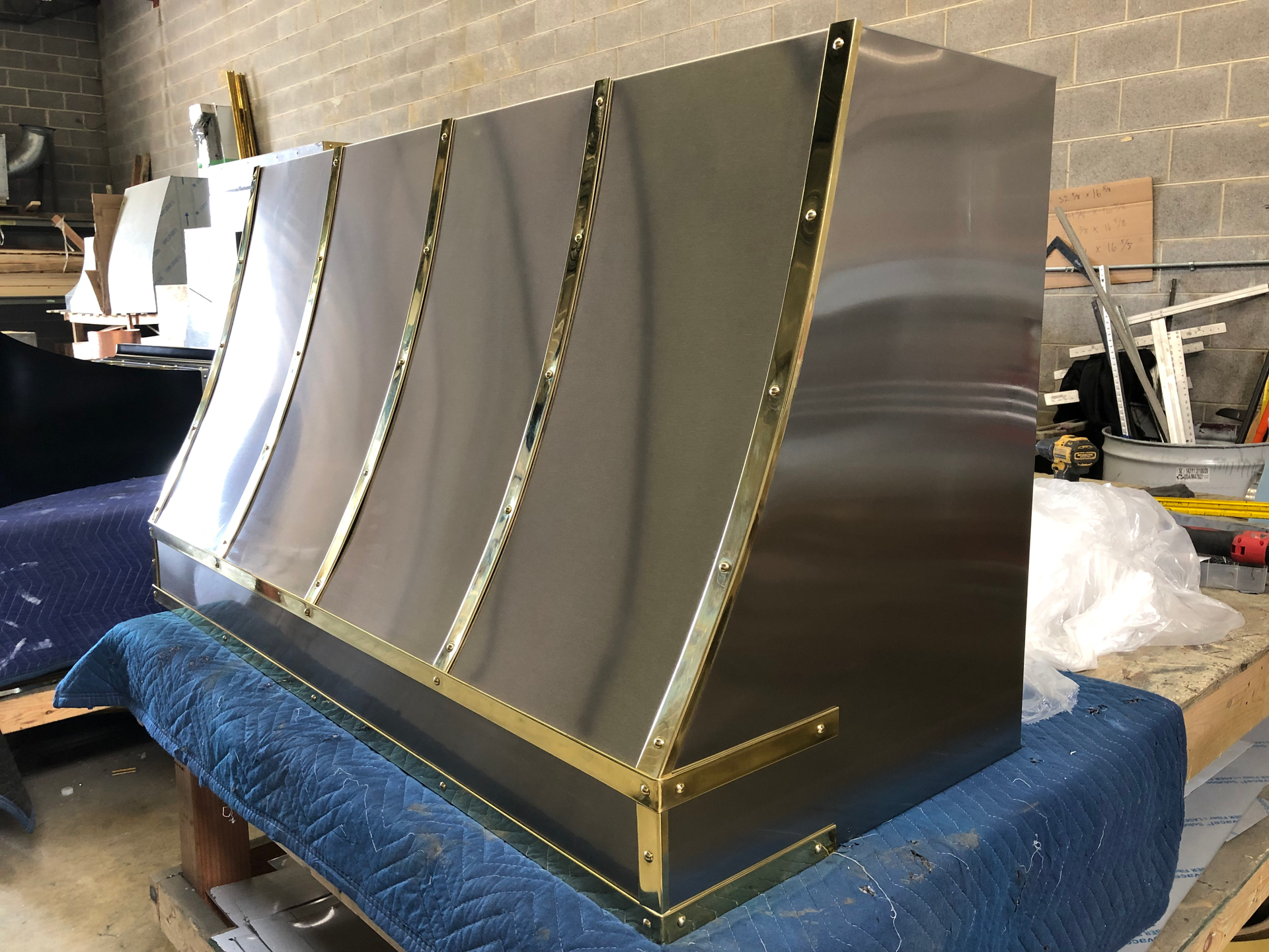 A stainless steel hood is sitting on top of a blue blanket.