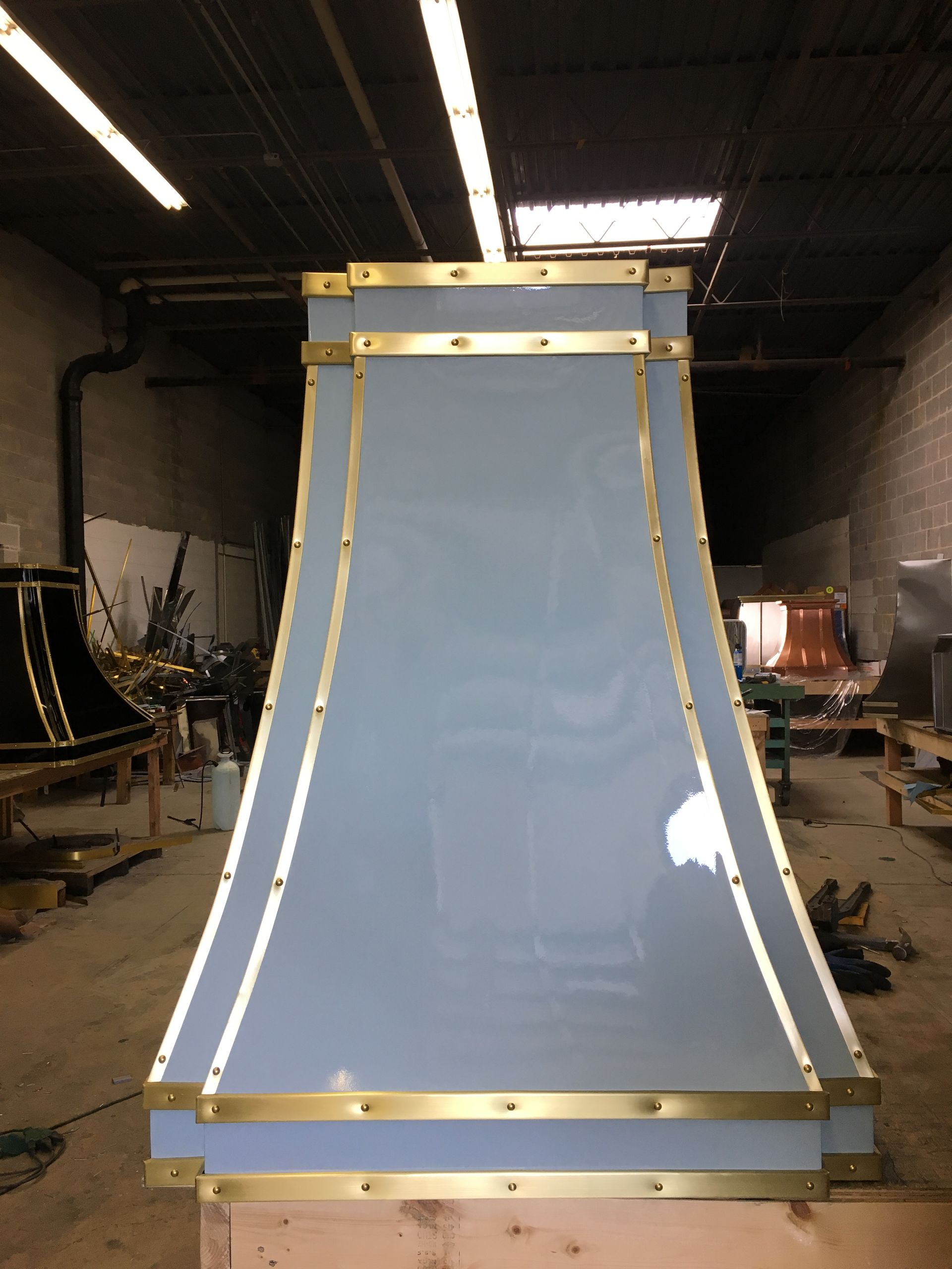 A blue and gold hood is sitting in a warehouse