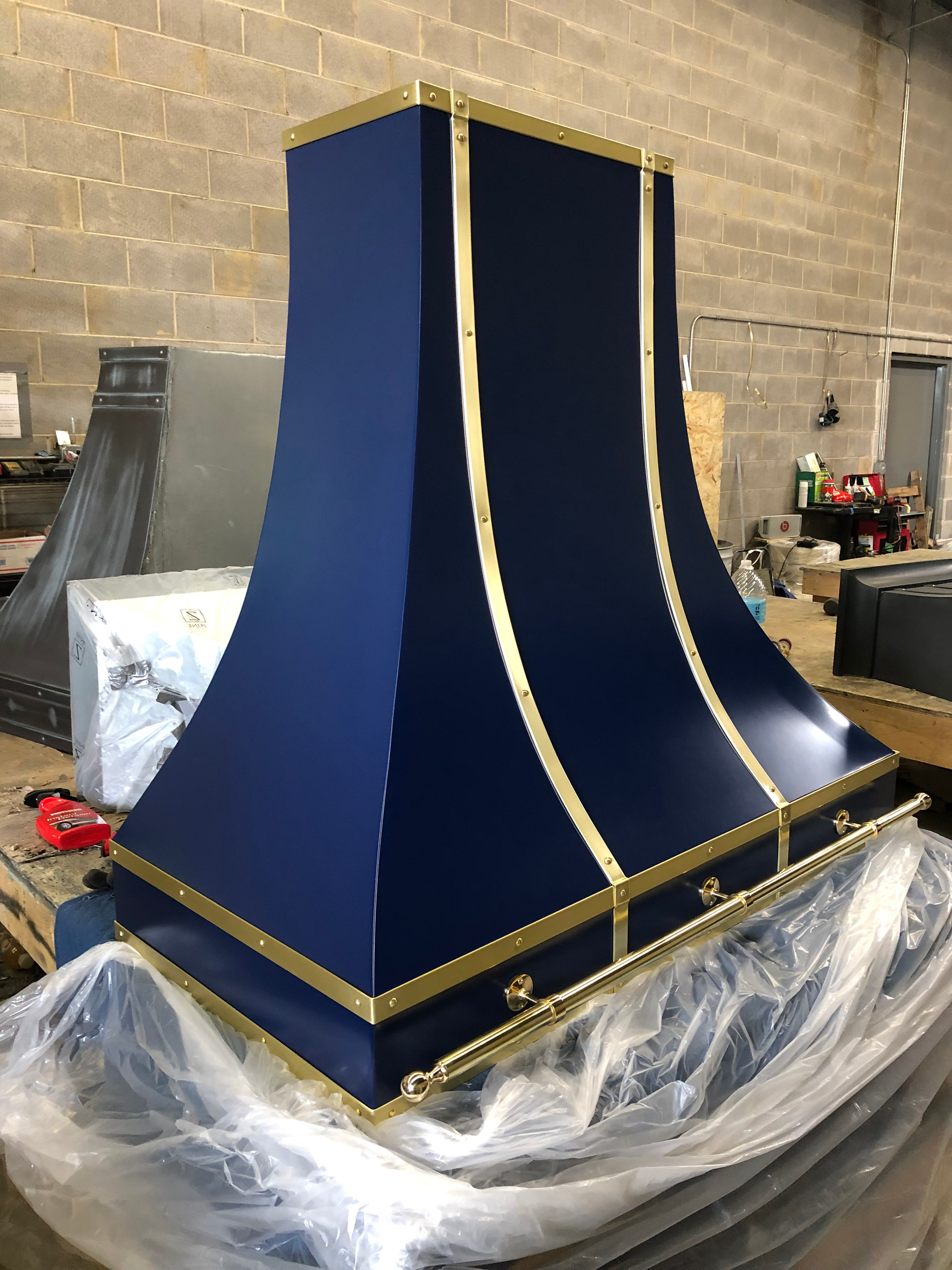 A blue and gold hood is sitting on top of a wooden table.