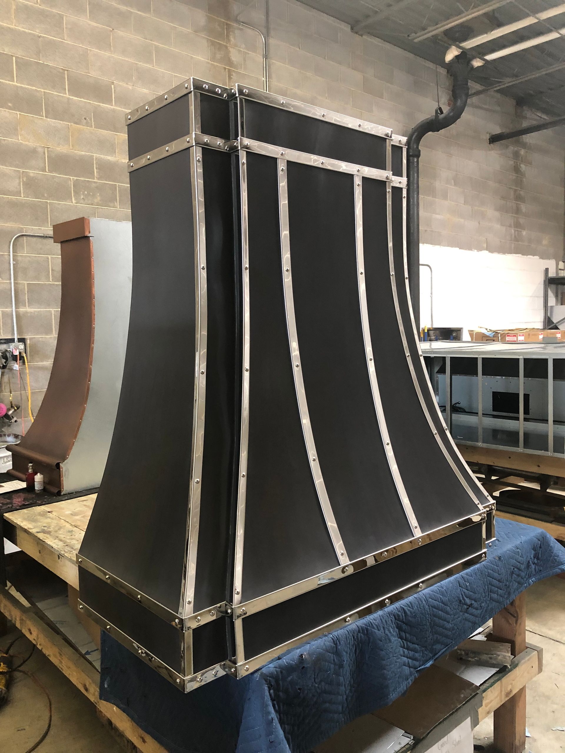 A black hood is sitting on top of a wooden table.