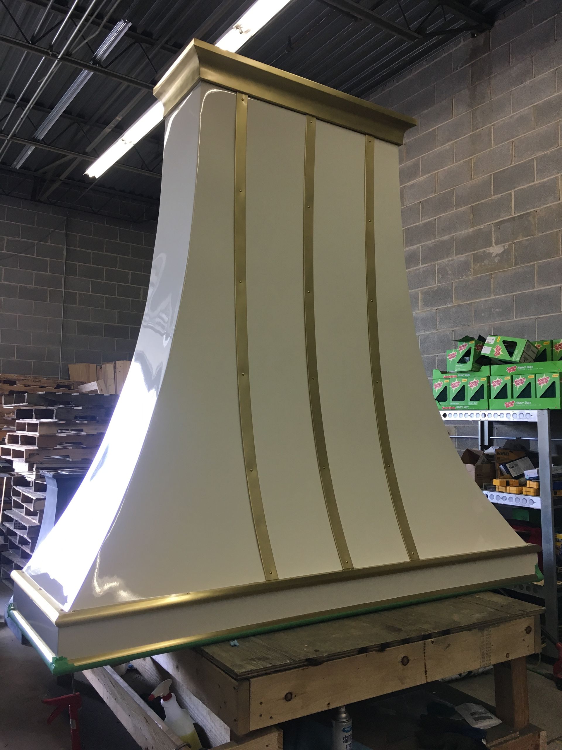 A white and gold hood is sitting on top of a wooden table.