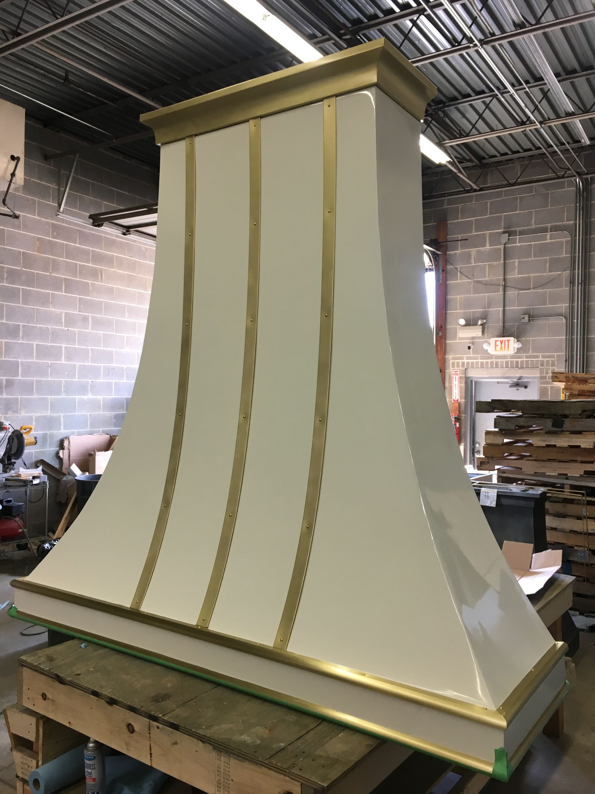 A white and gold hood is sitting on a wooden table.