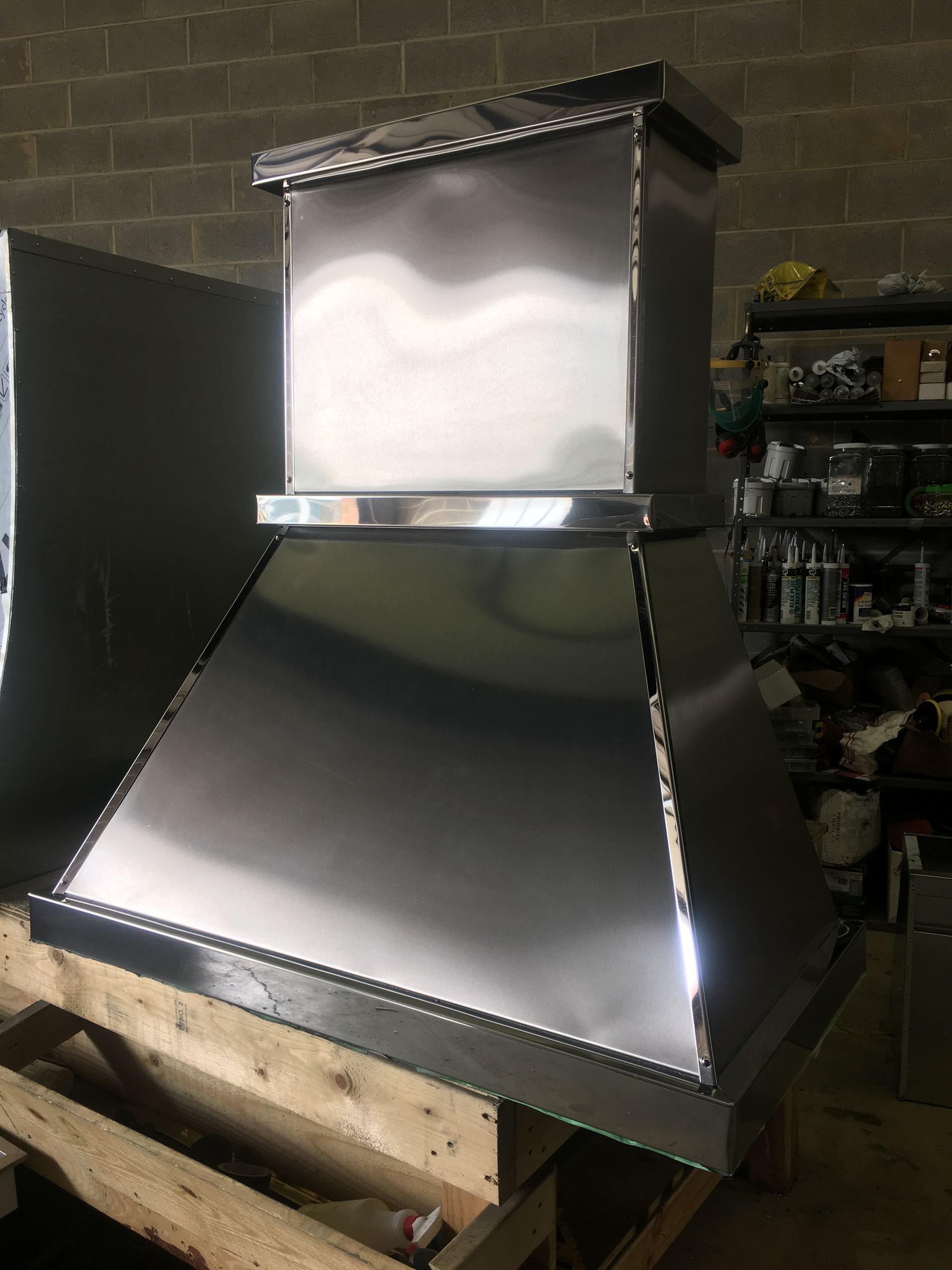 A stainless steel hood is sitting on top of a wooden table.