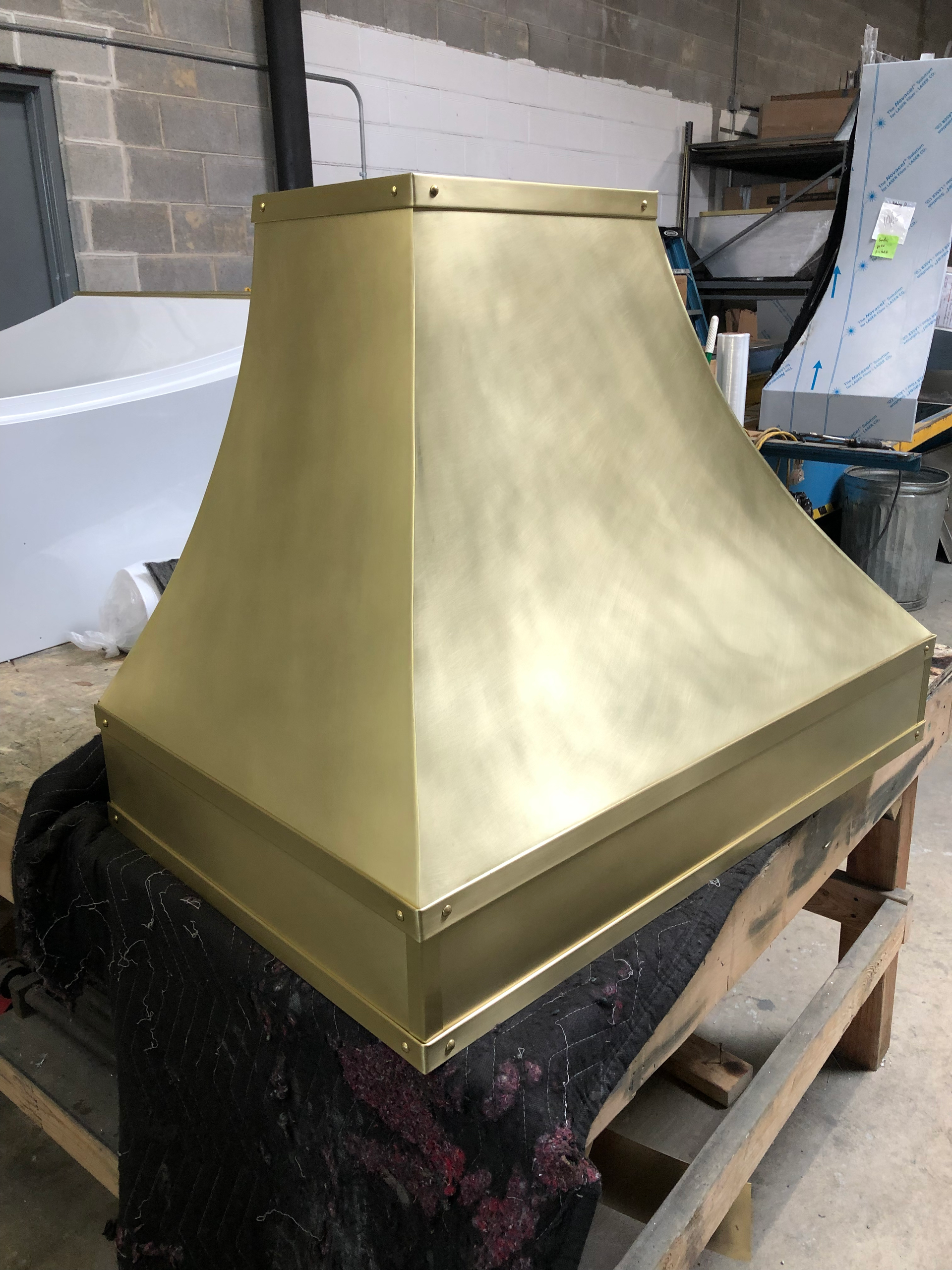 A brass hood is sitting on top of a wooden table.