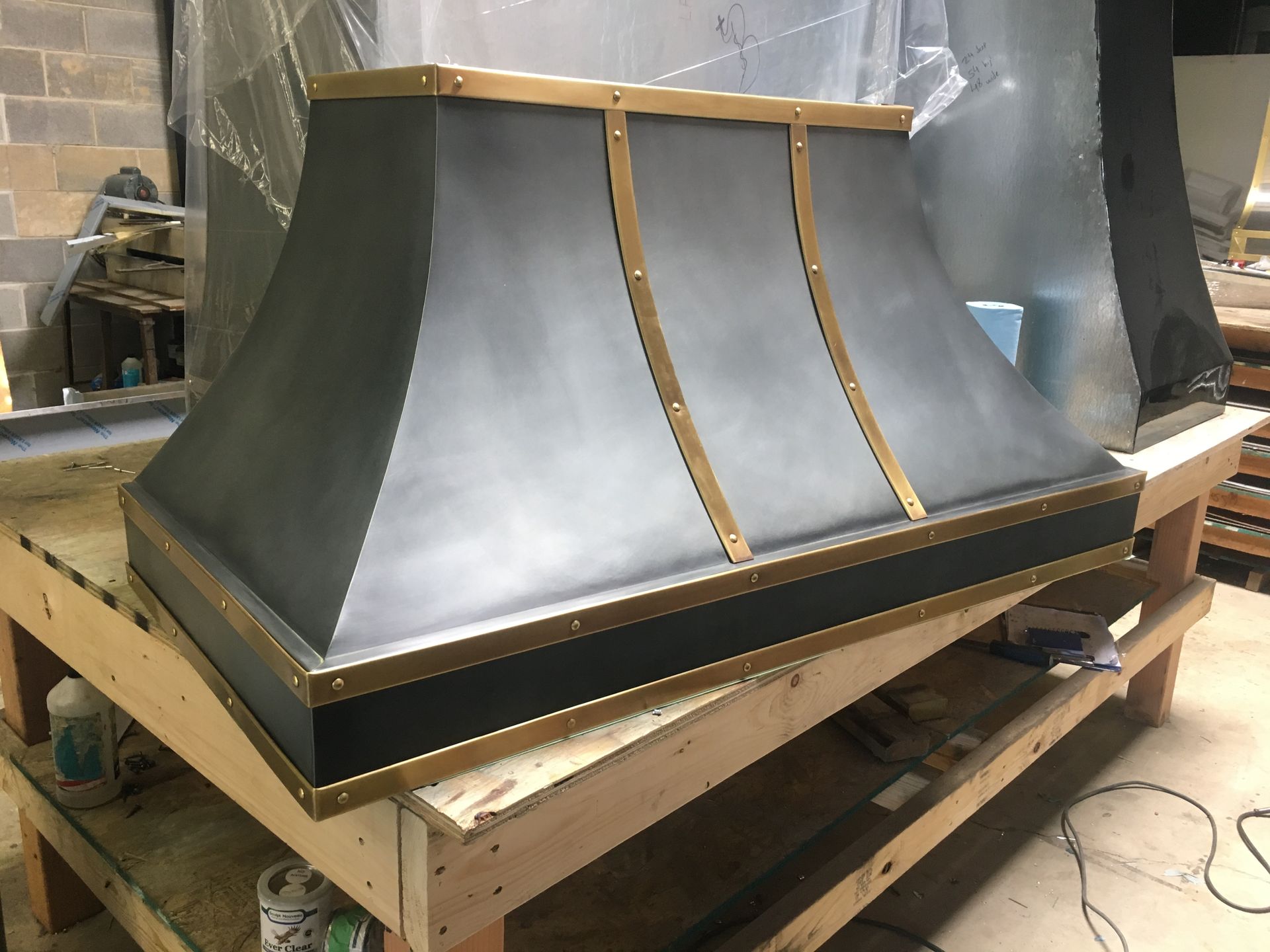 A metal hood is sitting on top of a wooden table.