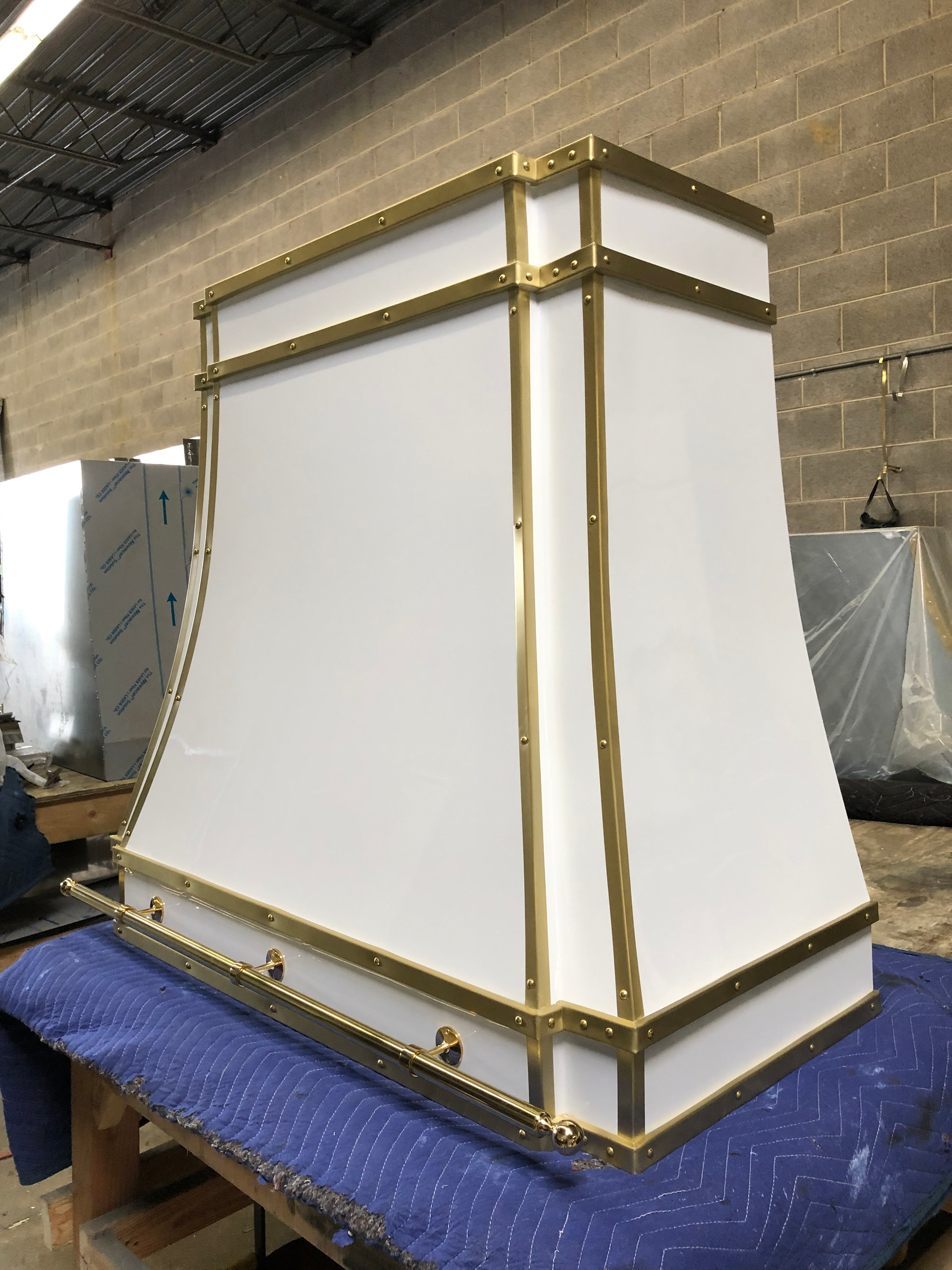 A white and gold hood is sitting on top of a blue table.