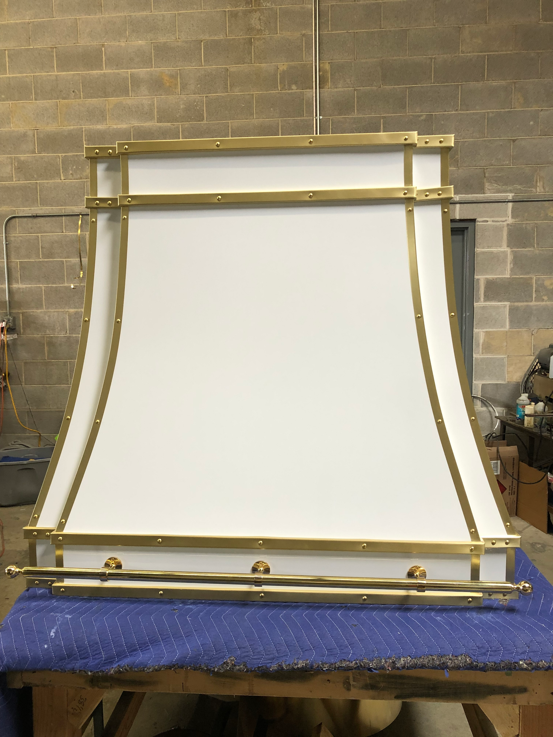 A white and gold hood is sitting on a blue table.