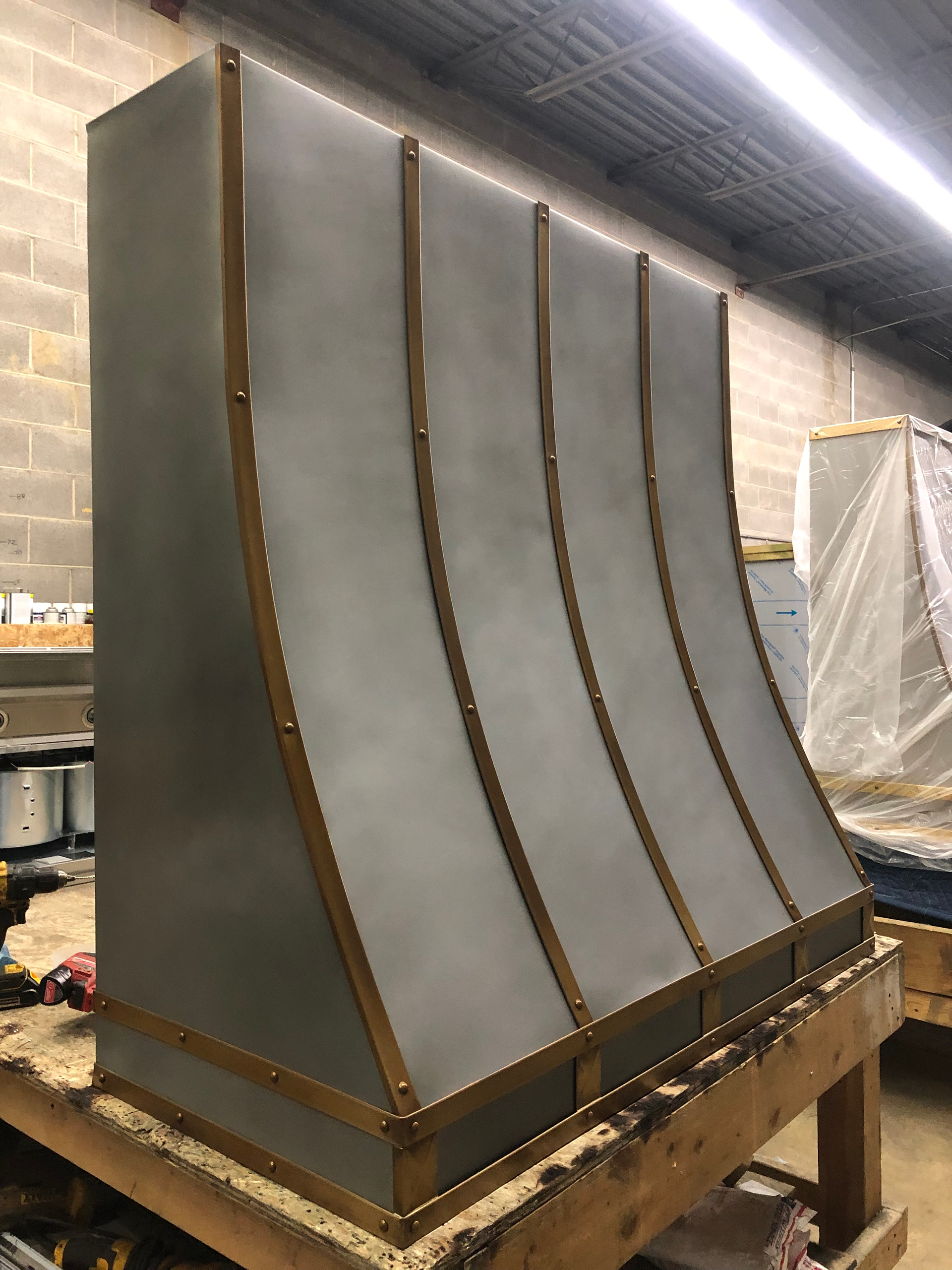A stainless steel hood is sitting on top of a wooden table.