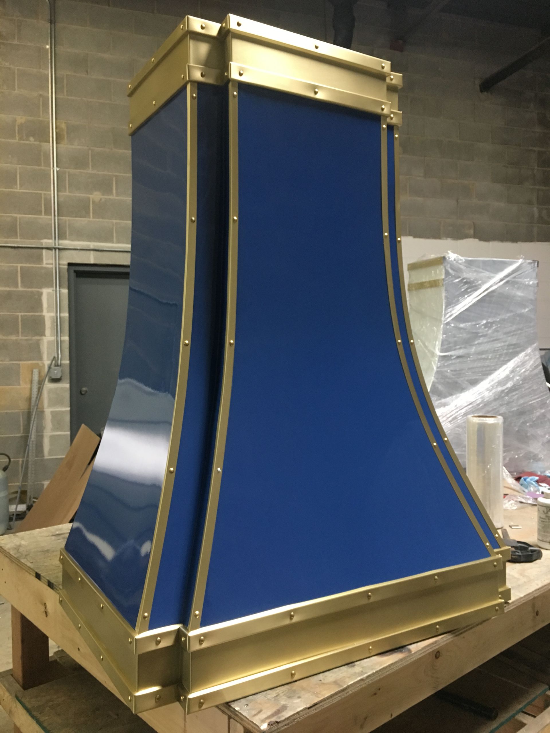 A blue and gold hood is sitting on a wooden table