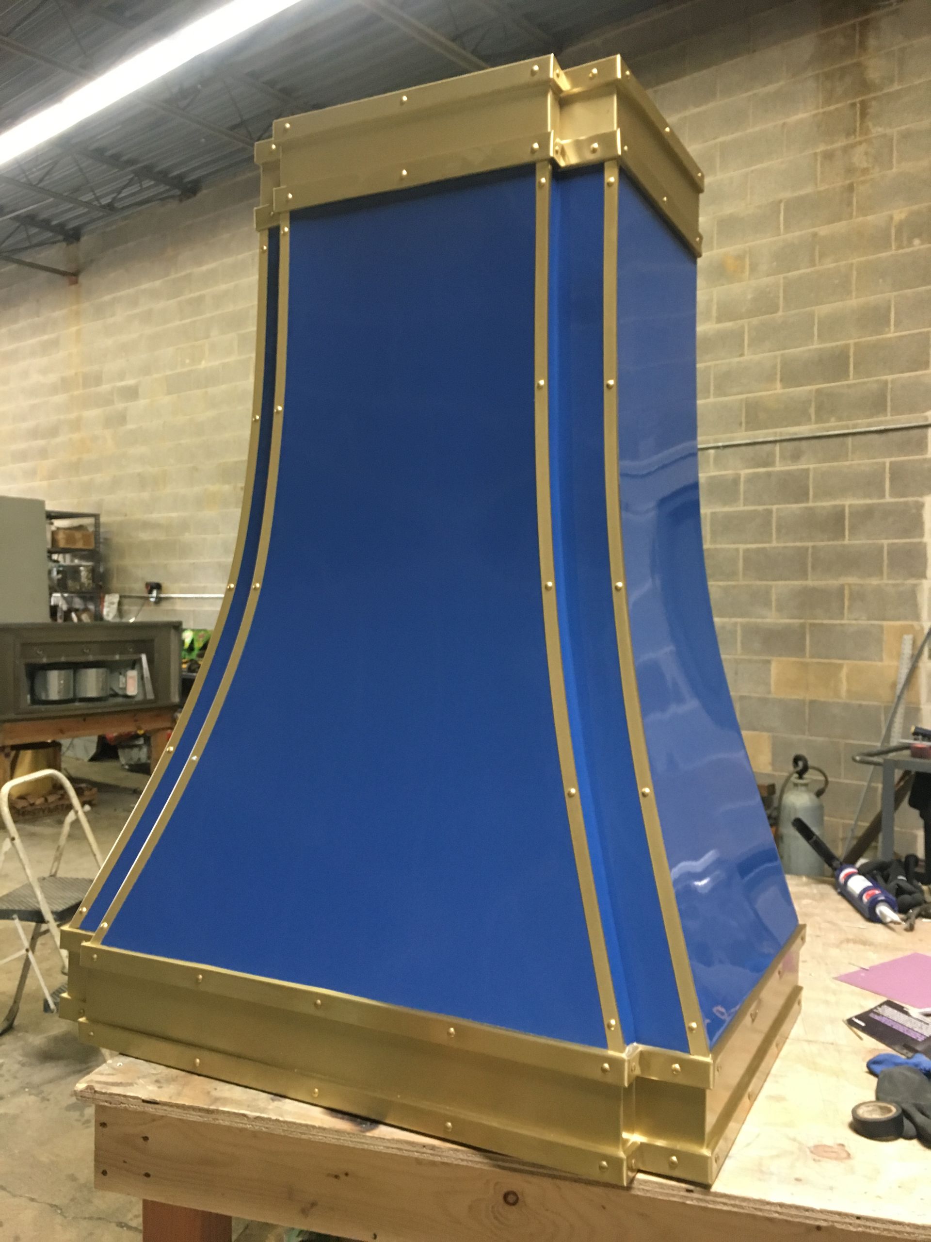 A blue and gold hood is sitting on a wooden table.