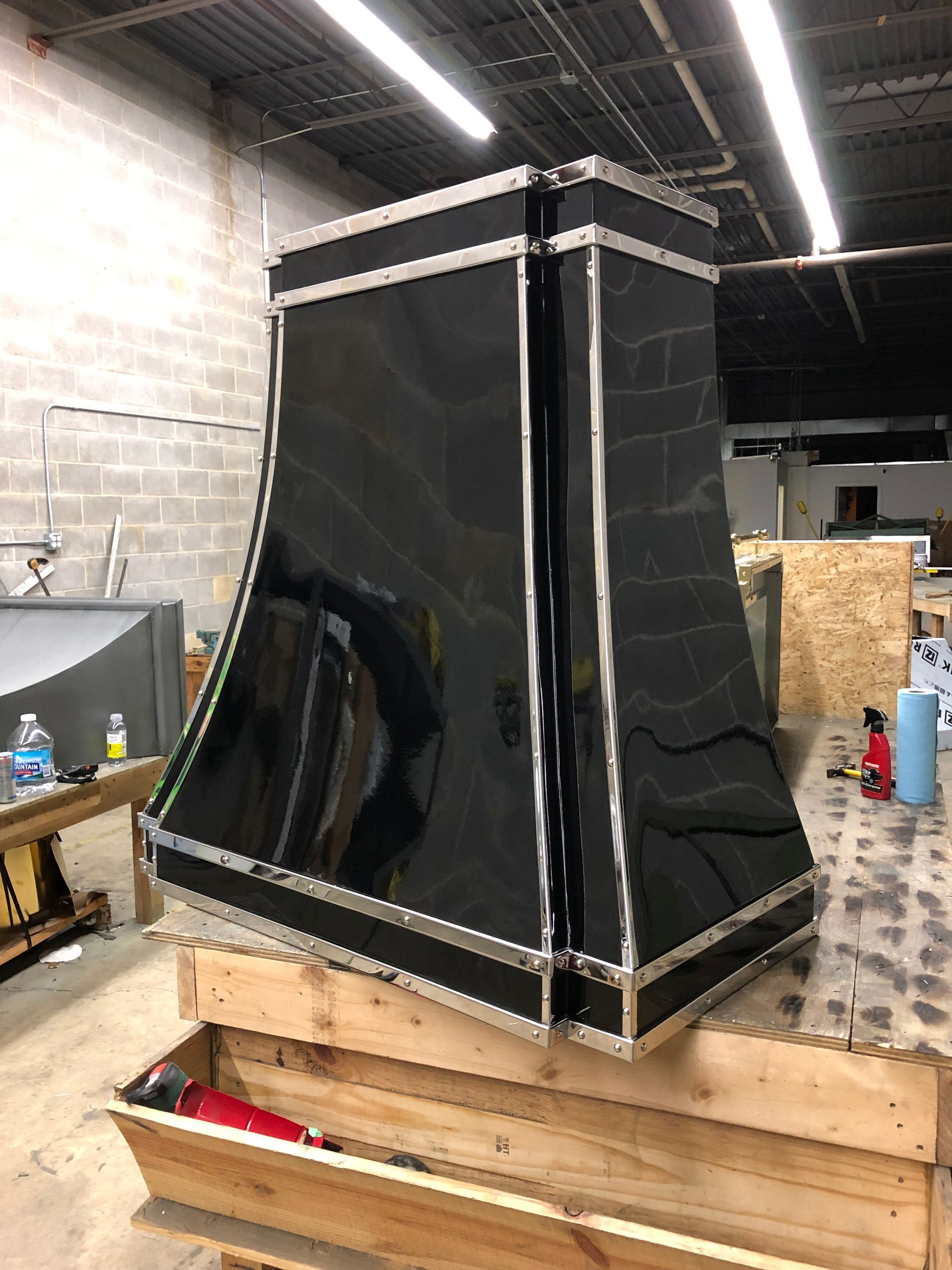 A black hood is sitting on top of a wooden table in a room.