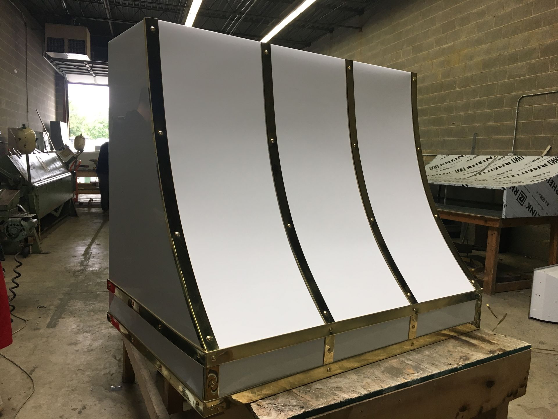A stainless steel hood is sitting on top of a wooden table.