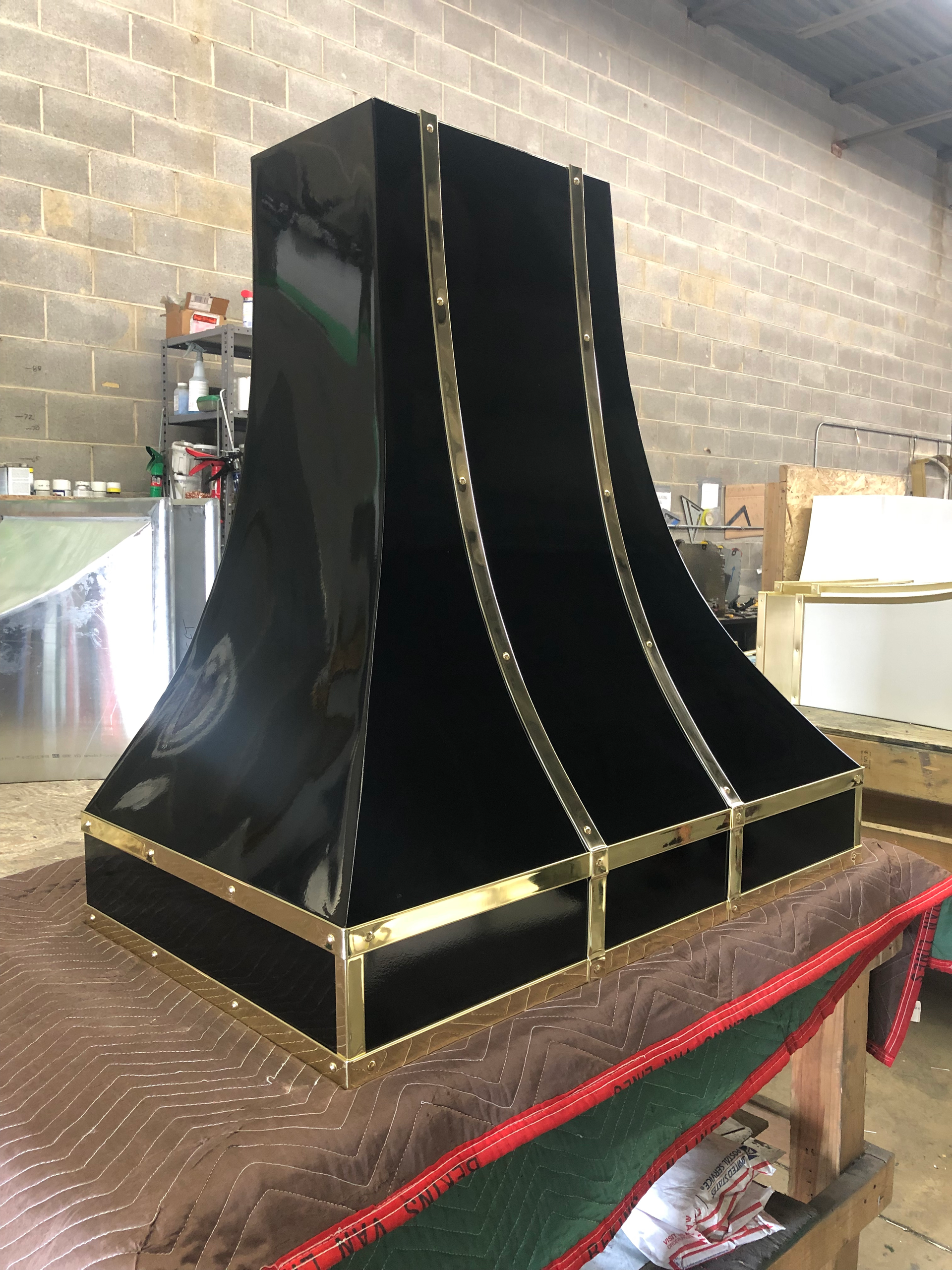 A black and gold hood is sitting on top of a table.